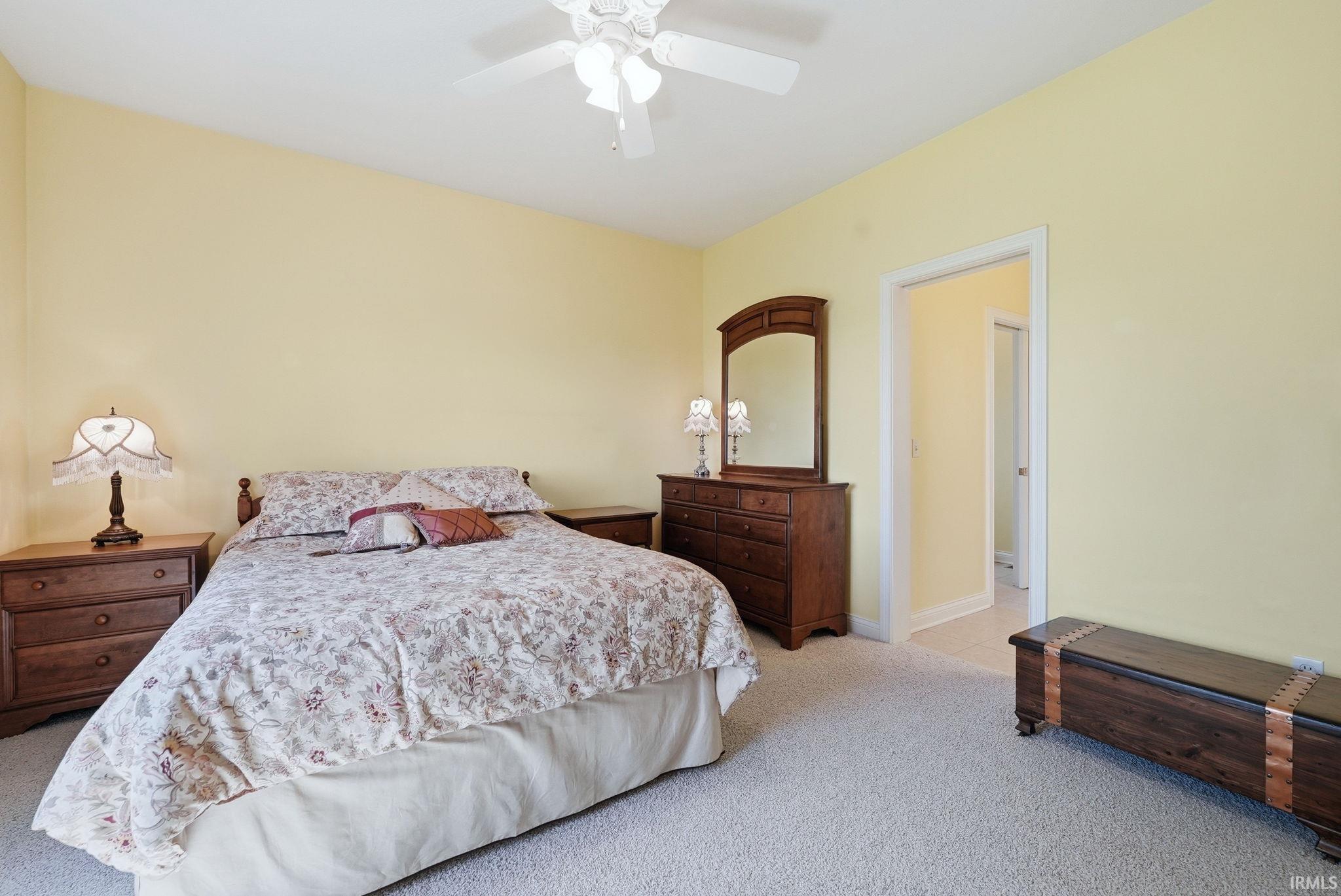 Carpeted room with a ceiling fan light fixture and pale yellow walls