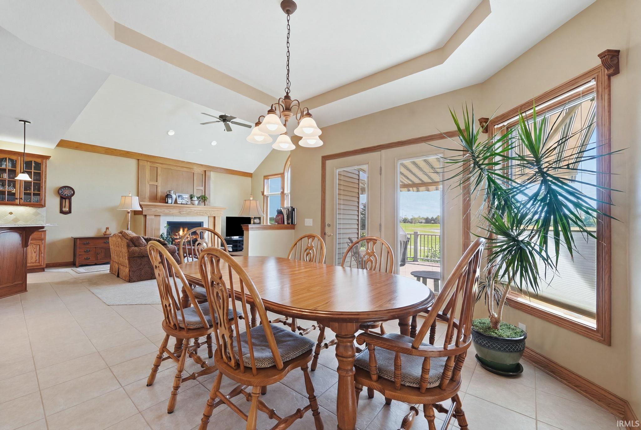 Open-concept living area with a vaulted ceiling and a tray ceiling detail