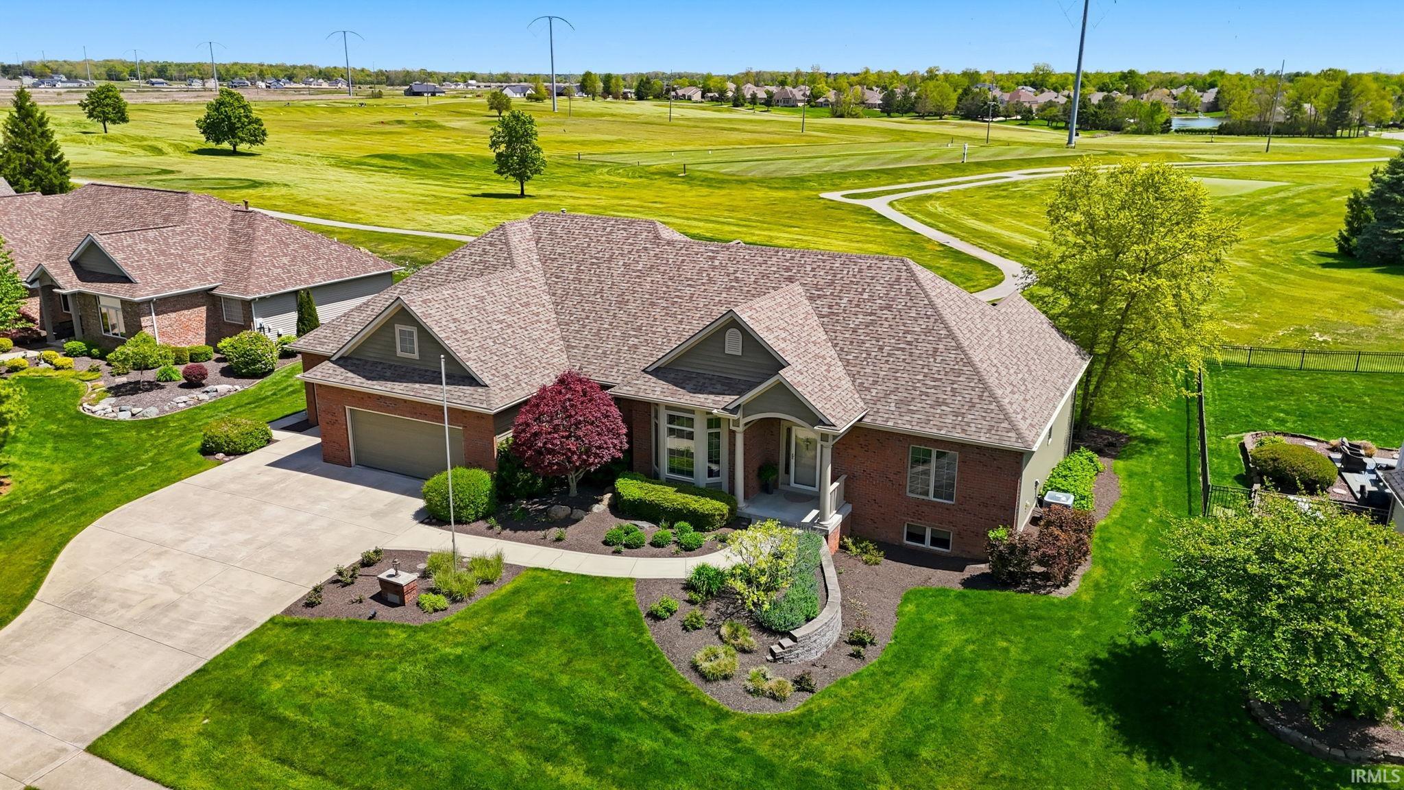Brick exterior with a gabled roofline, concrete driveway, and a two-car garage