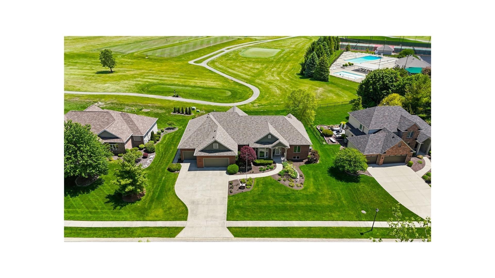 Traditional brick home with an attached two-car garage, mature landscaping, and a concrete driveway