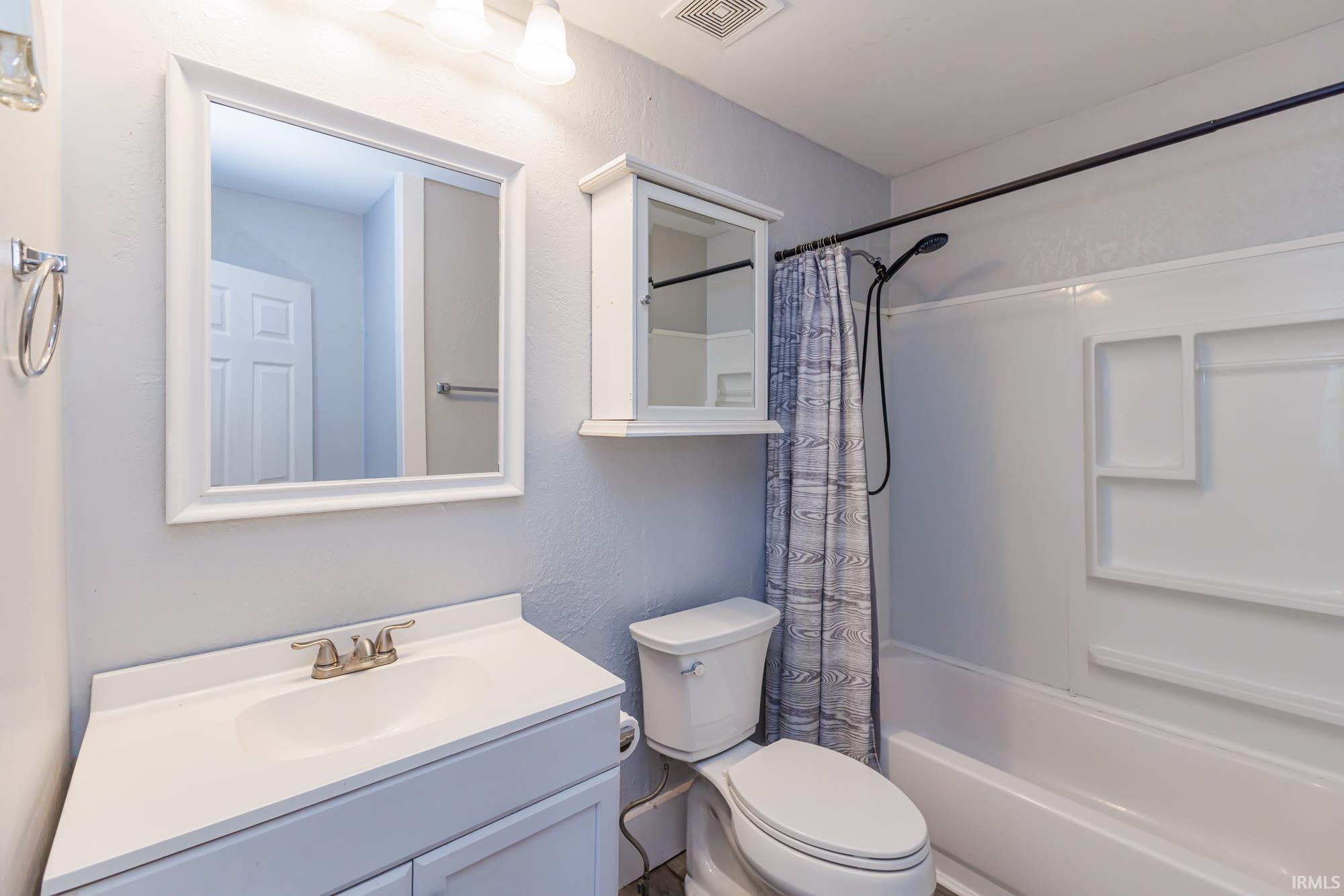 Bathroom featuring a white vanity with integrated sink, framed mirror, and chrome faucet