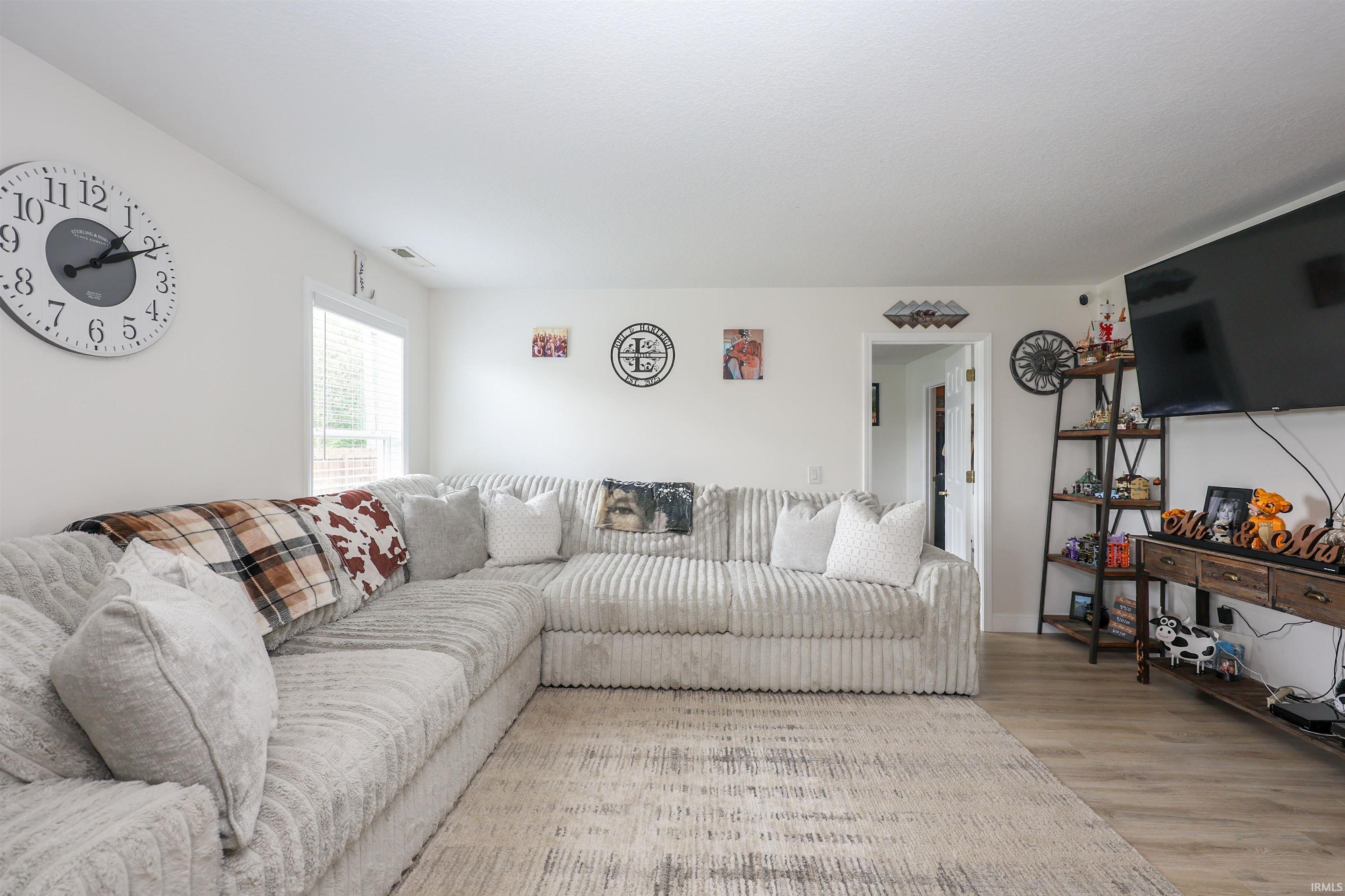 Bright living area featuring light-toned wood-finish flooring