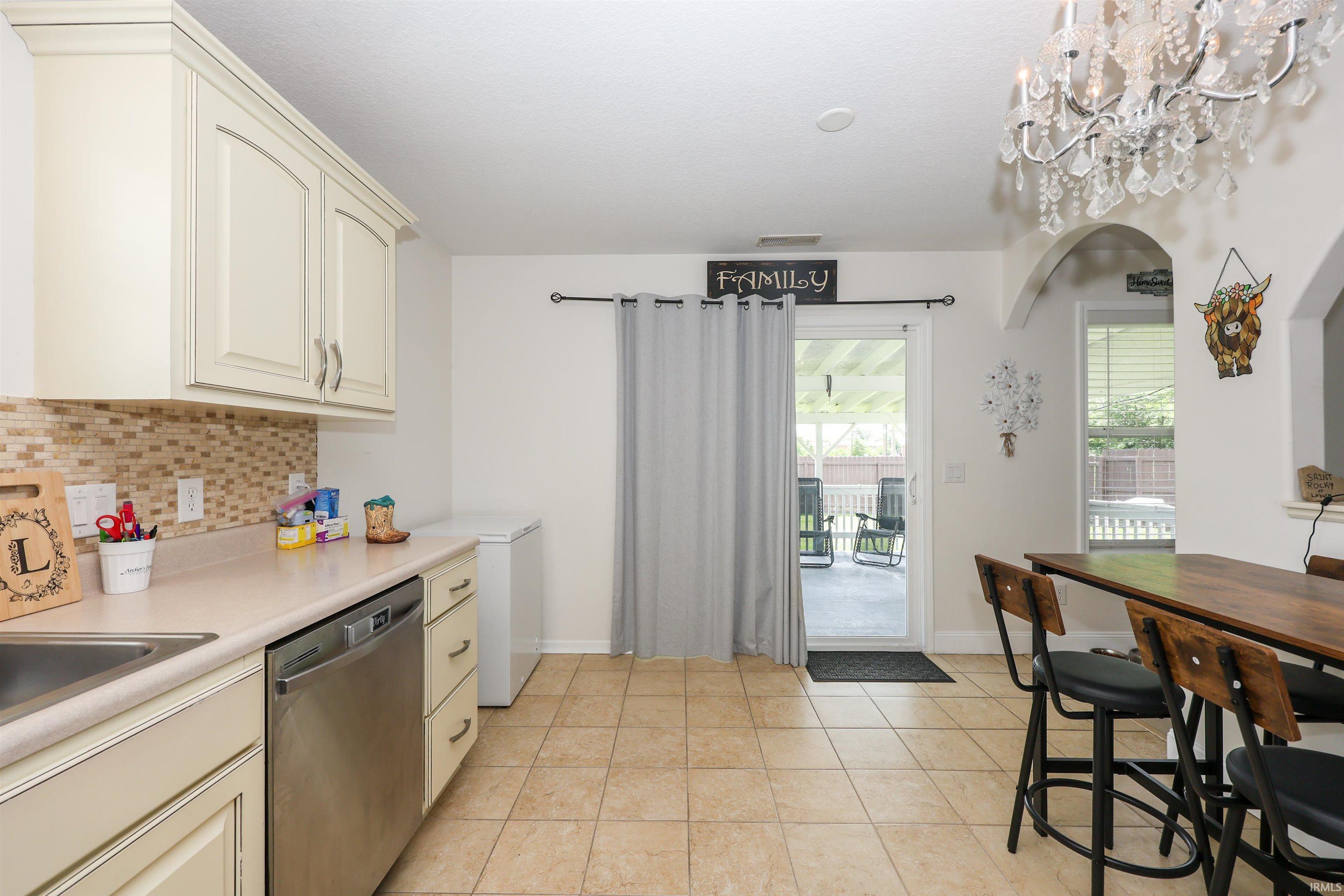 Kitchen featuring light-toned cabinetry, a mosaic tile backsplash, and tile flooring