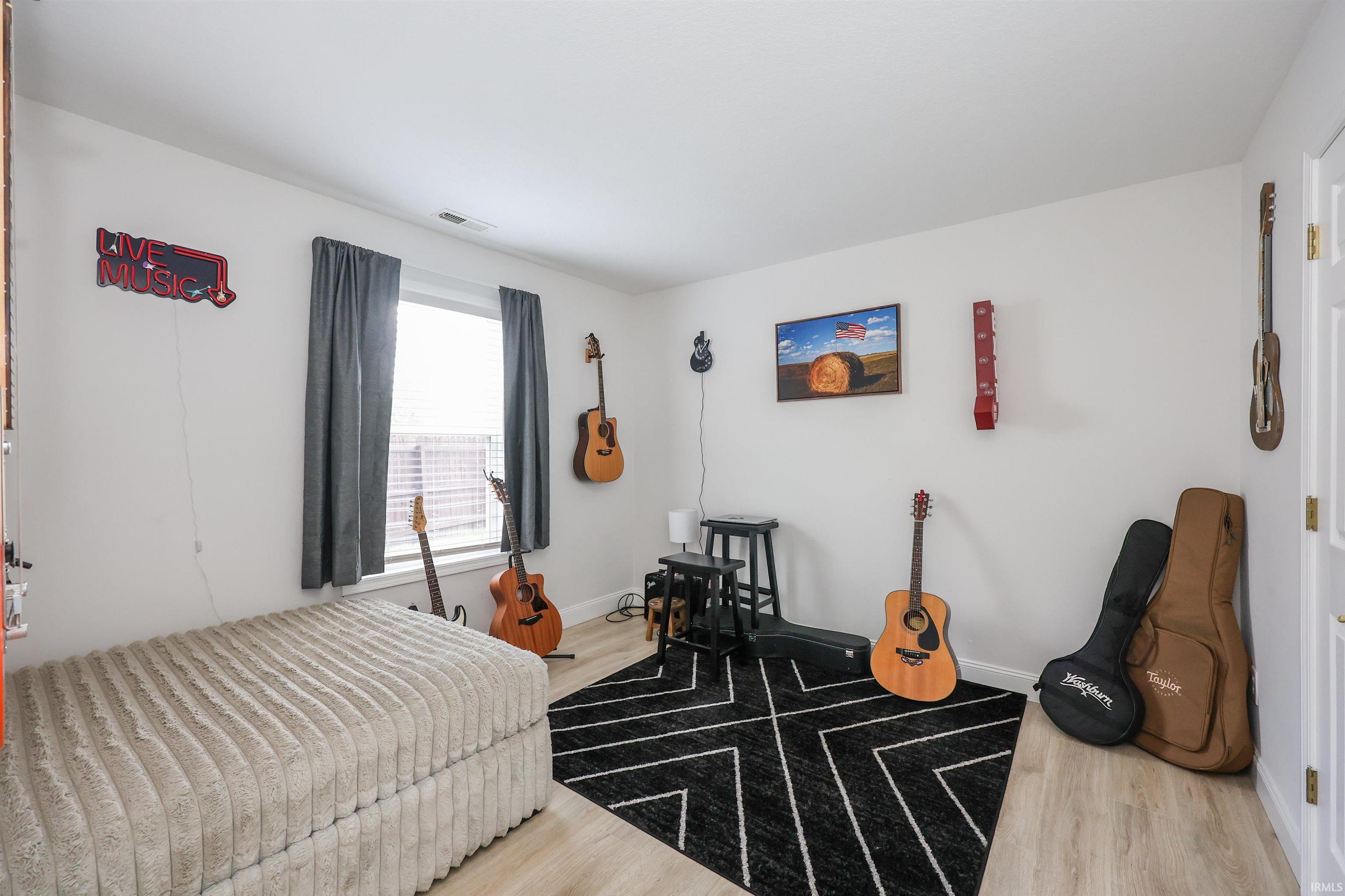 Light wood-finish flooring with a contrasting geometric area rug