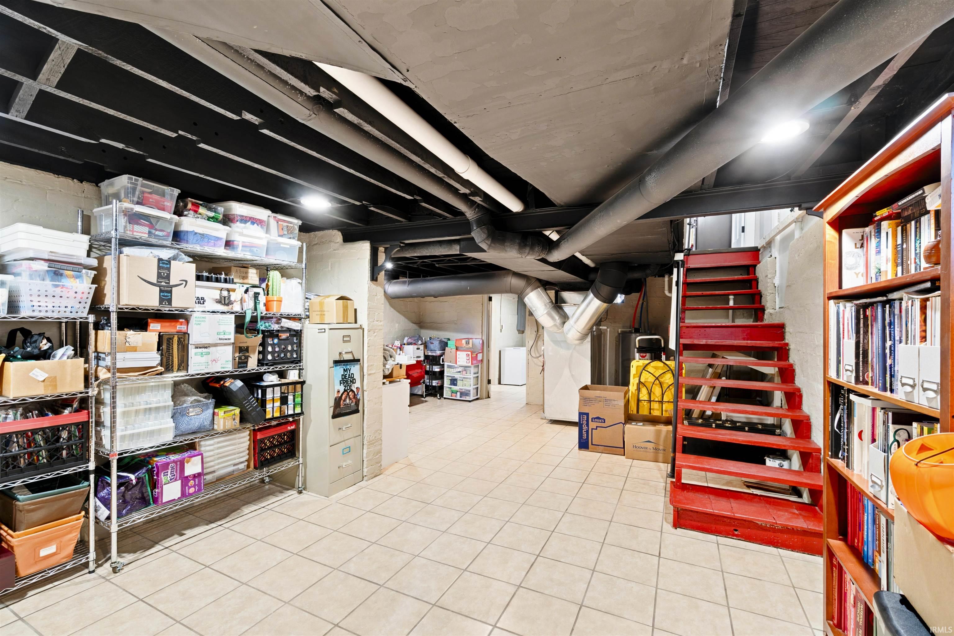 Spacious lower level featuring tile flooring and painted exposed ceiling joists