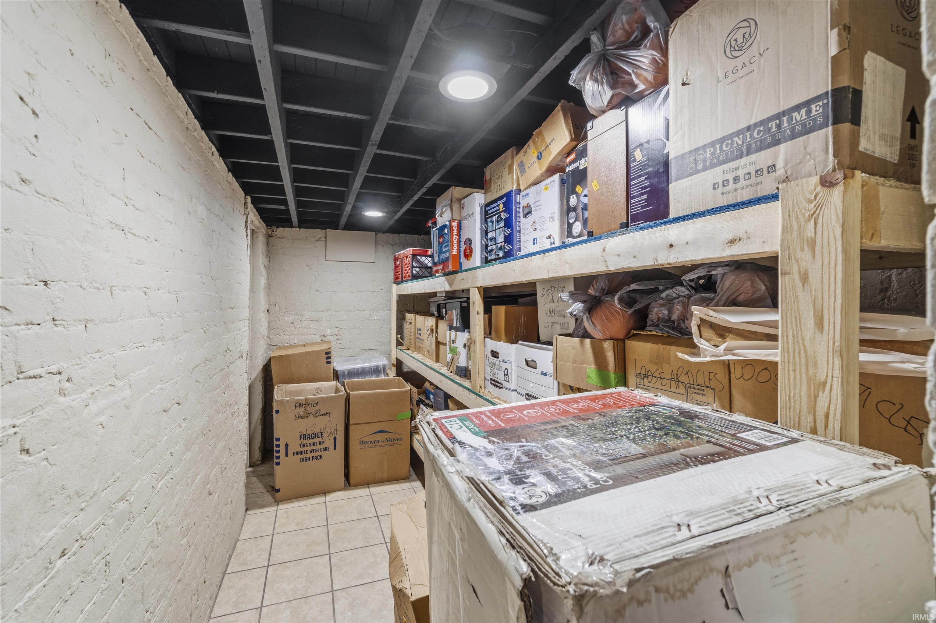Painted brick walls and exposed ceiling joists with recessed lighting