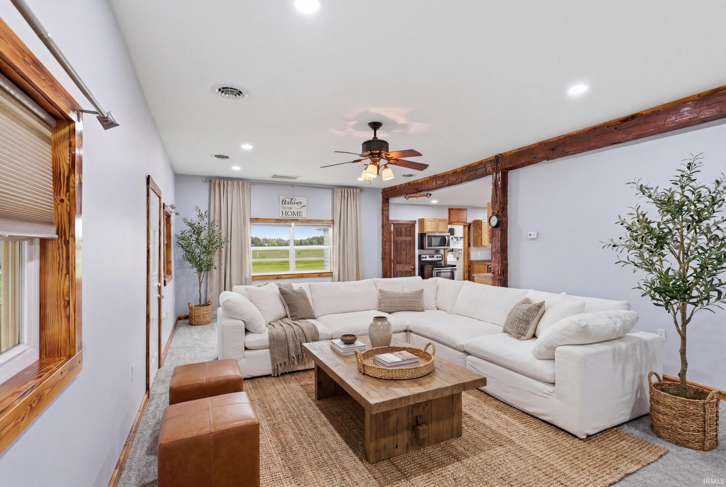 Spacious living area featuring exposed wood beams and light-toned walls