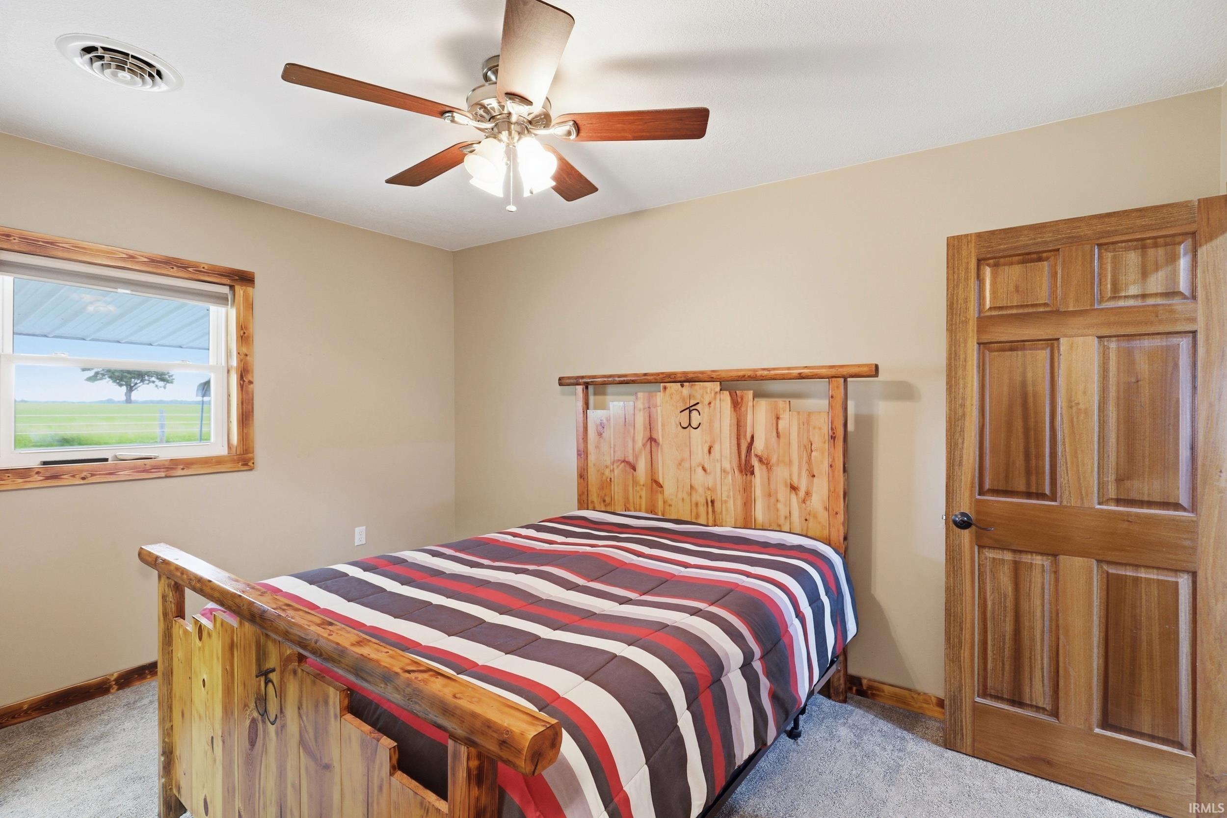Bedroom featuring wood-finish door, window trim, and baseboards