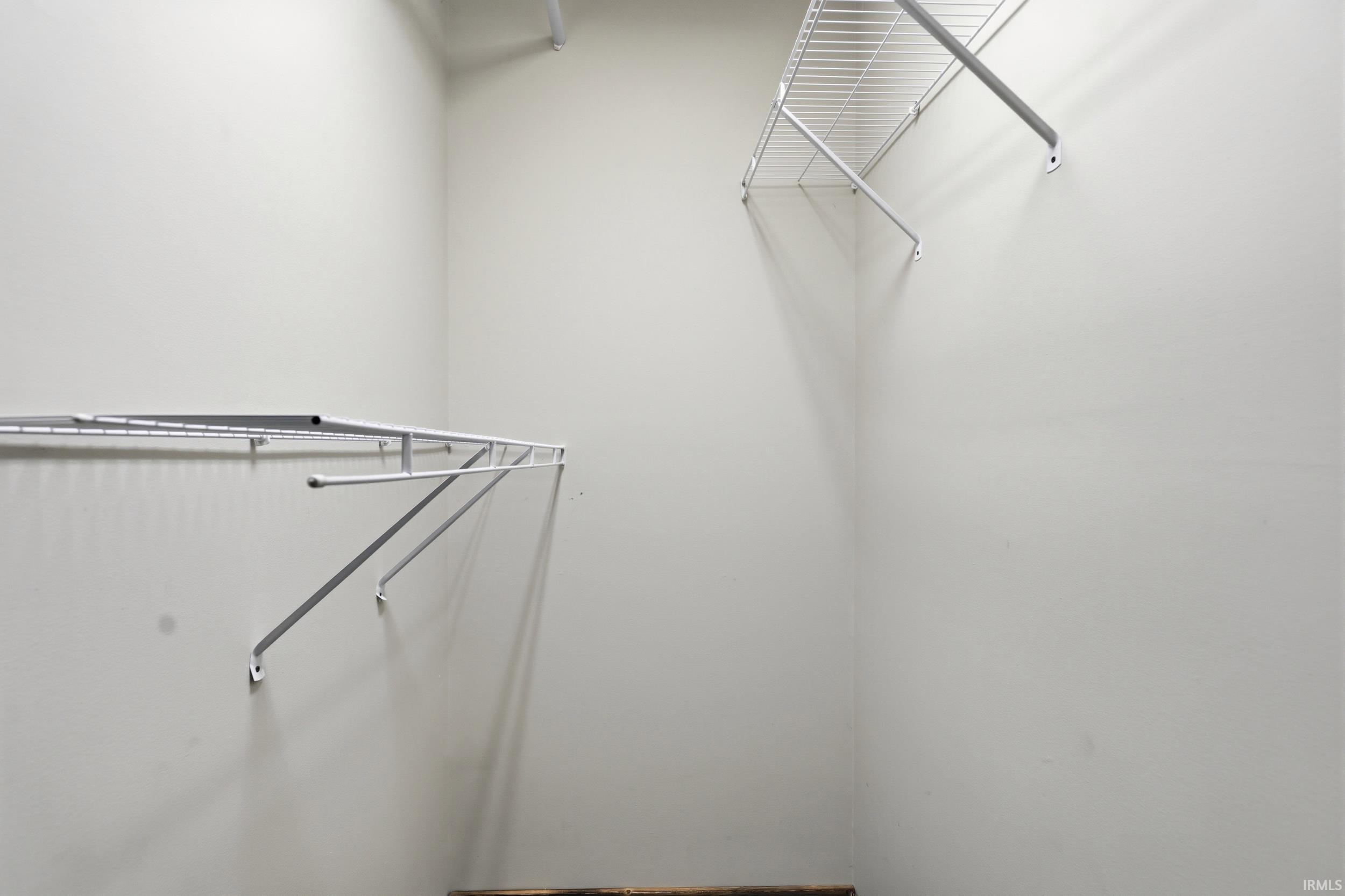 Organized closet space featuring white wire shelving and hanging rods