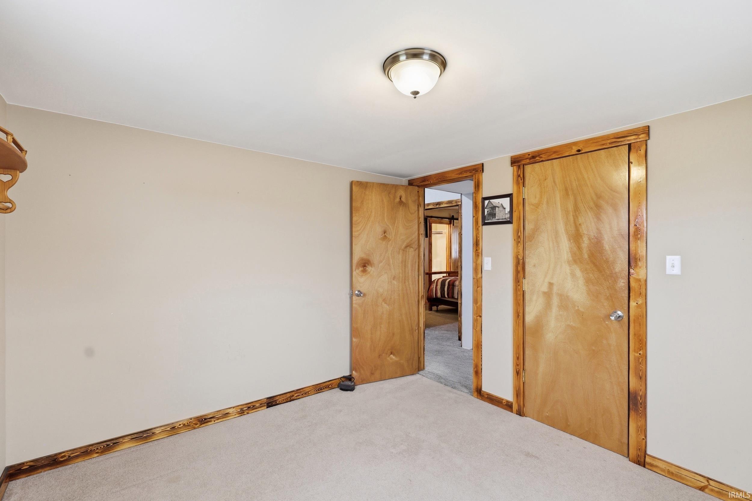 Neutral wall color with two wood doors featuring knotty wood trim
