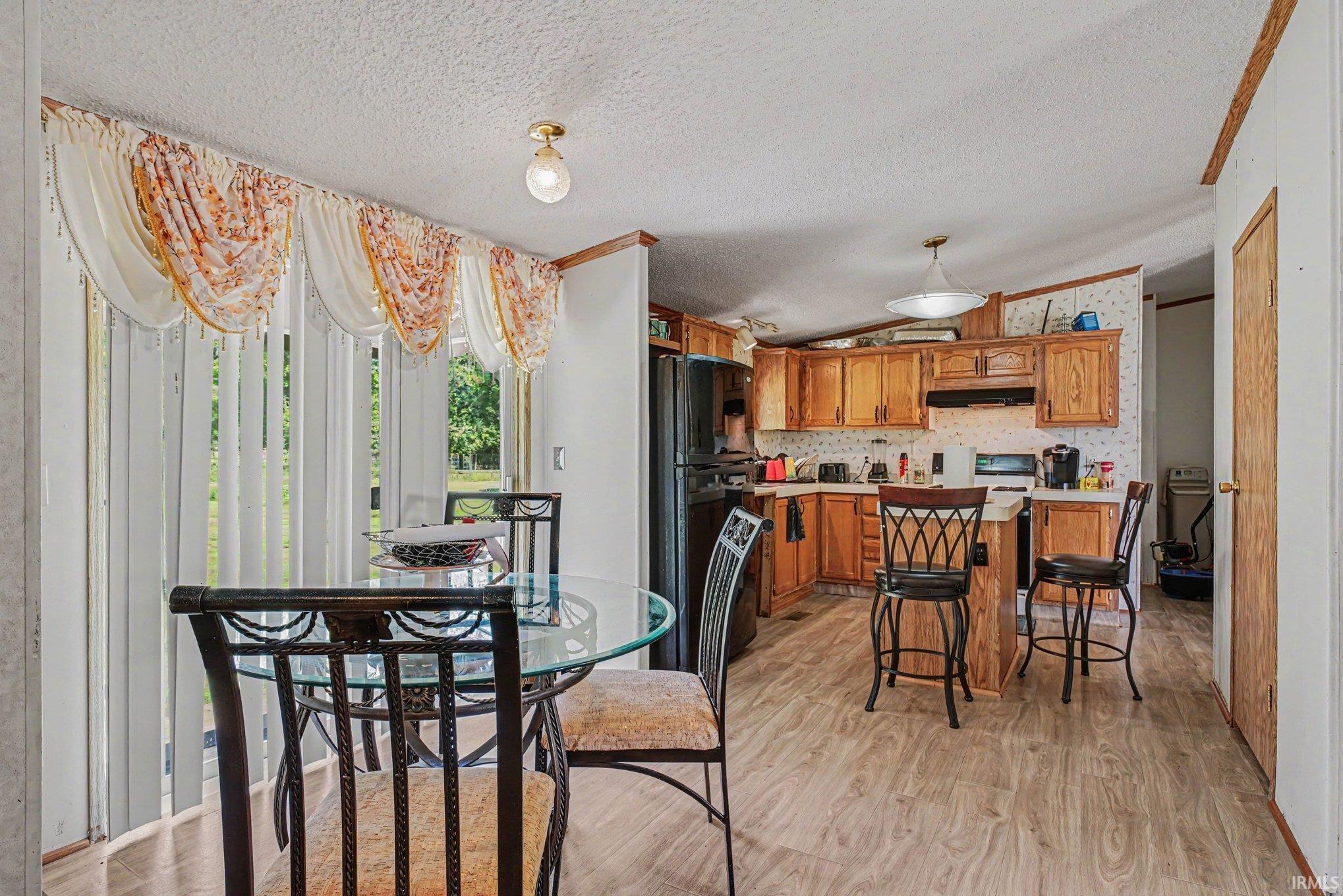 Kitchen dining area featuring wood-finish flooring and a glass patio door