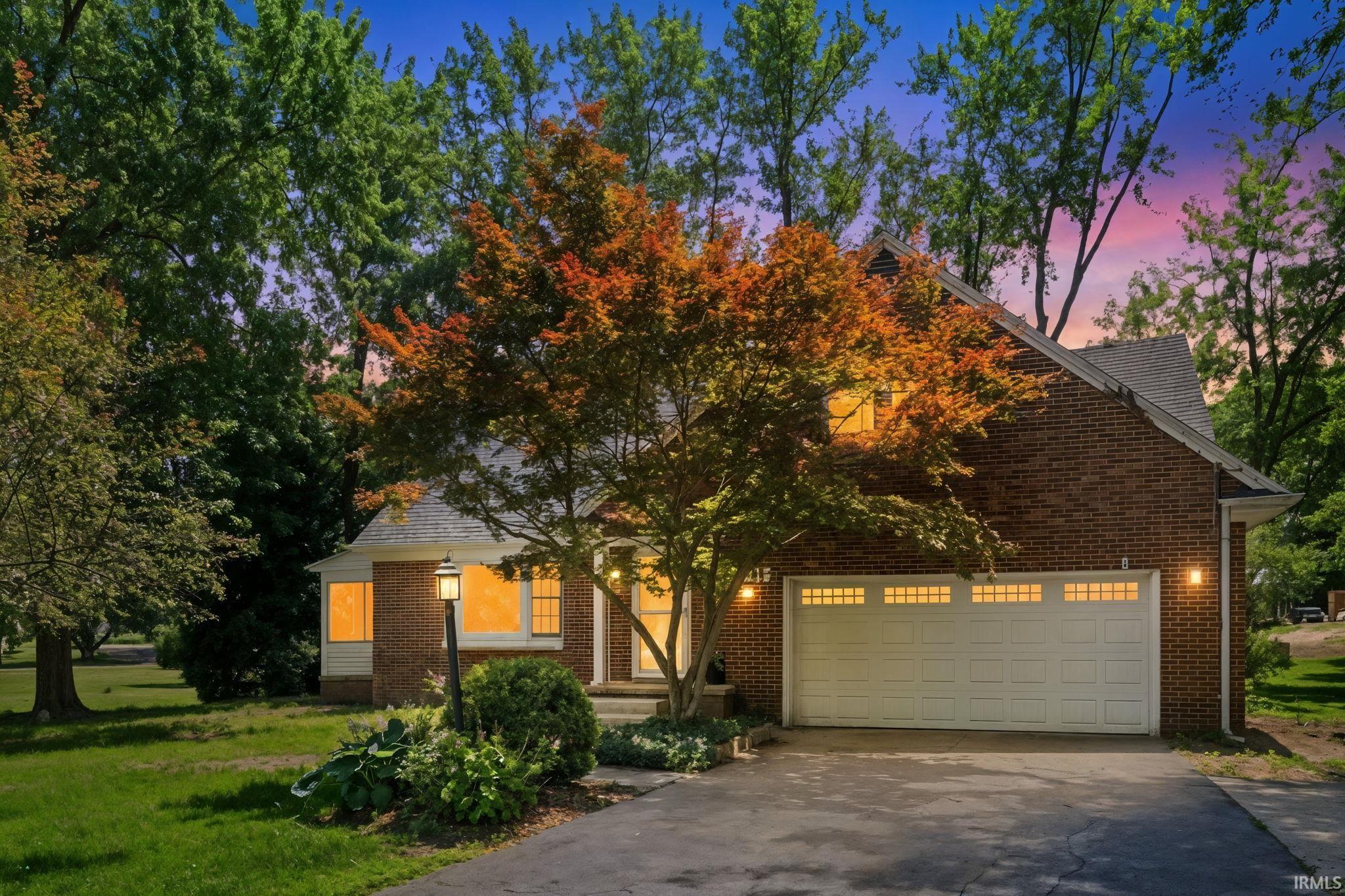 Brick exterior residence with an attached garage featuring transom-style windows