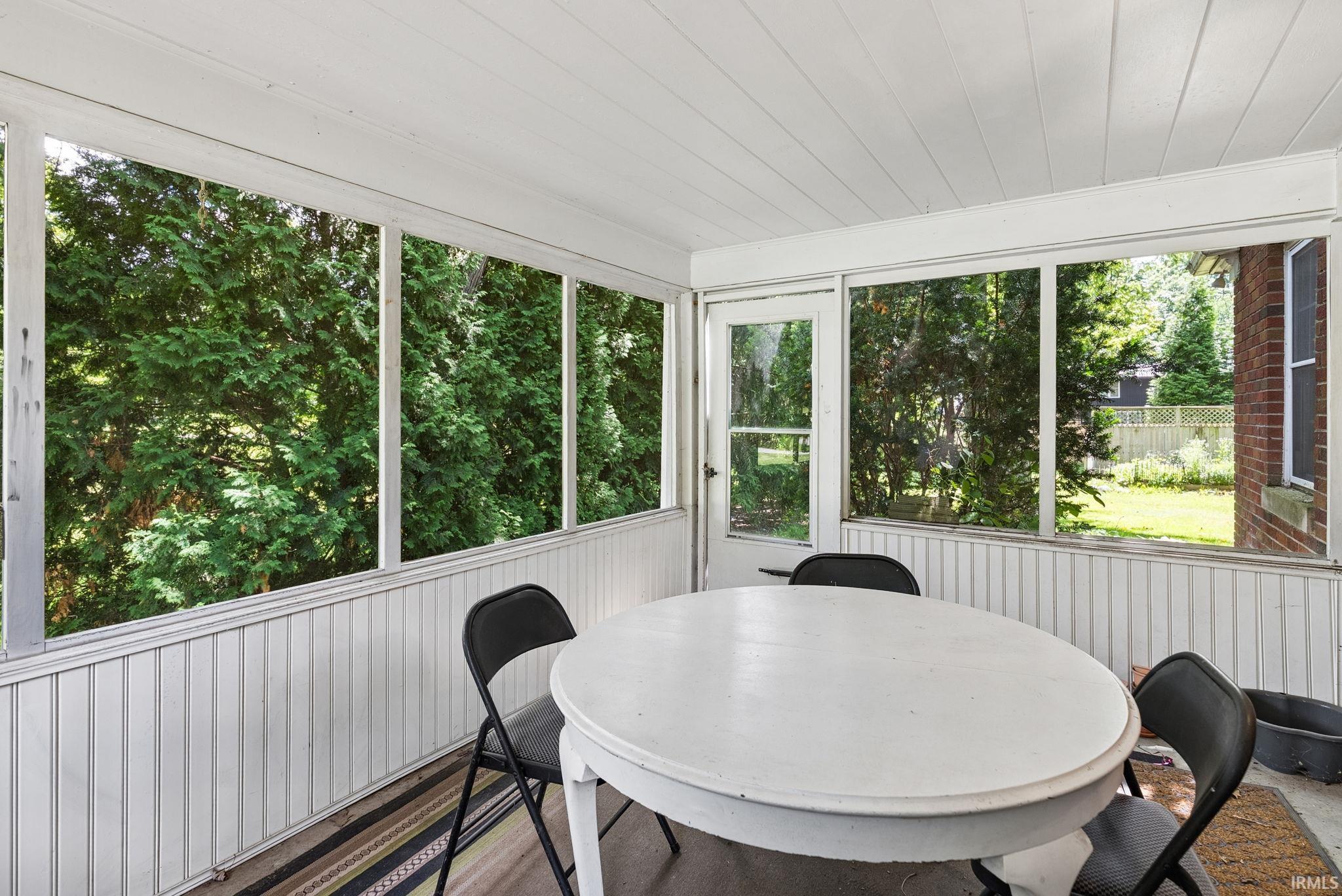 Screened porch with white tongue-and-groove paneling, white ceiling, and a white screen door