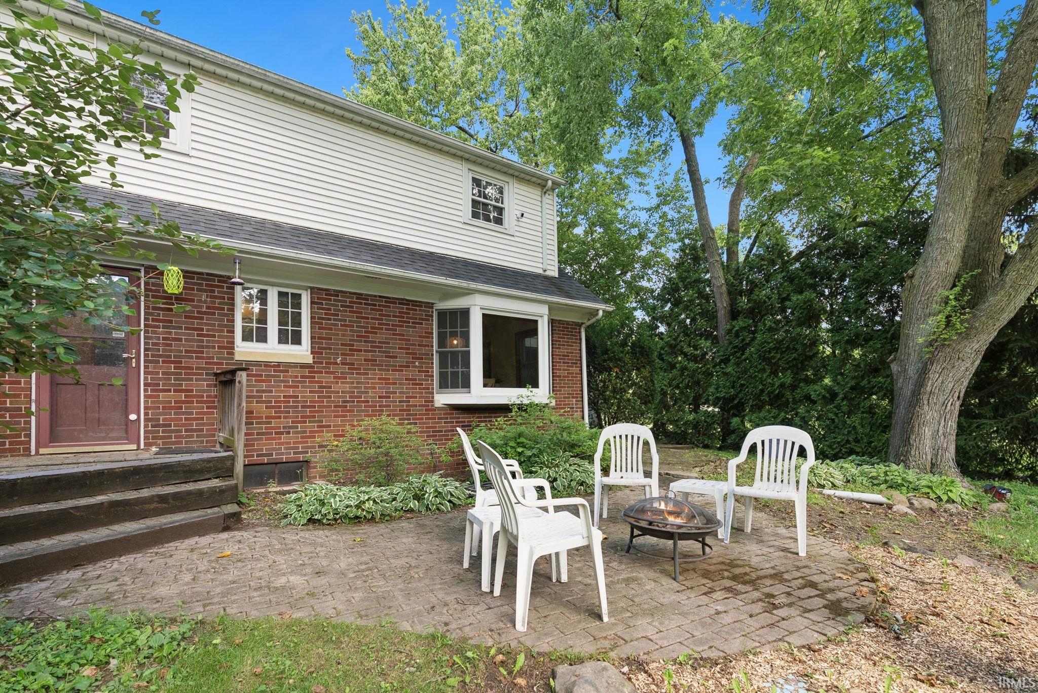 Exterior brick and siding construction featuring a bay window and a rear patio