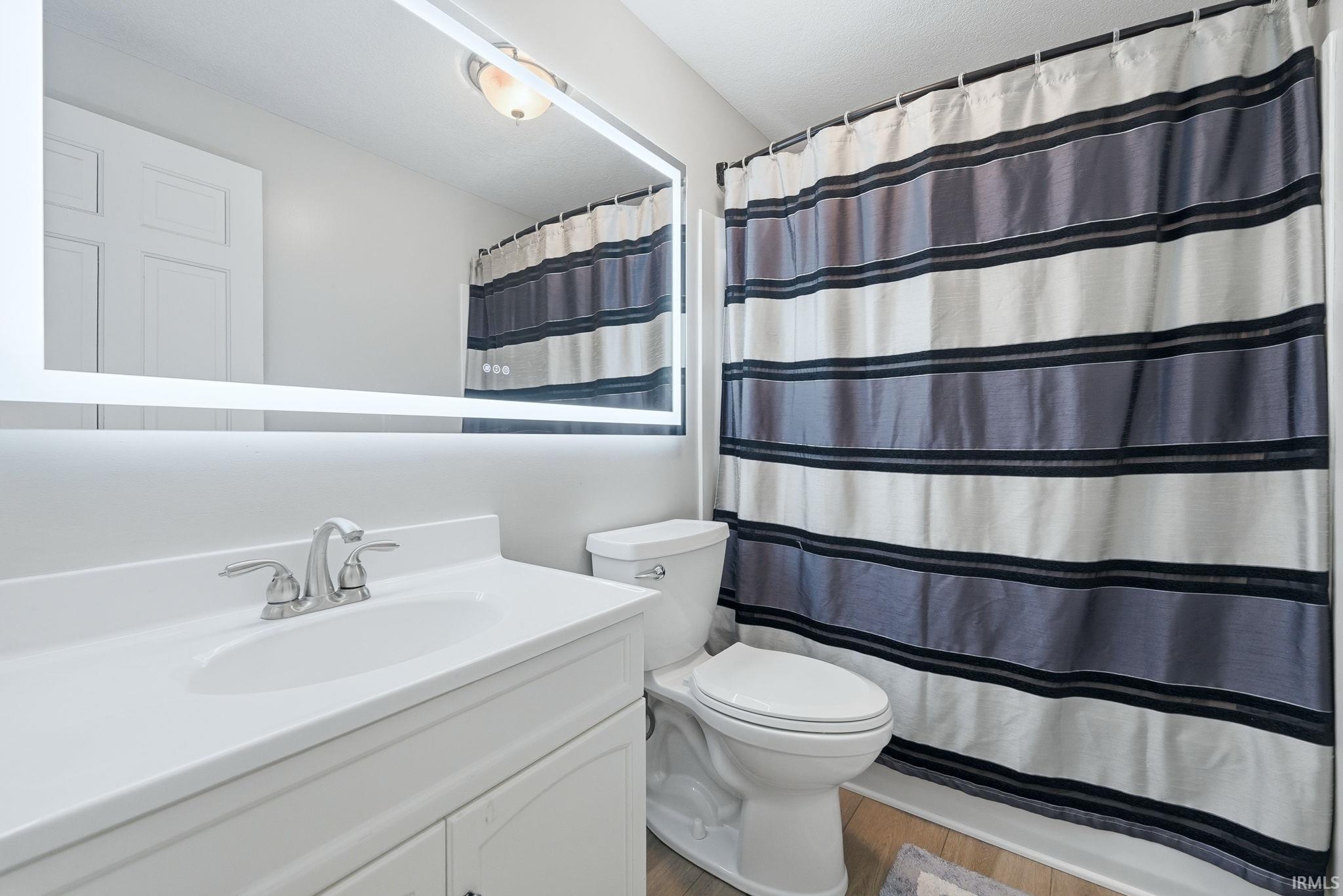Bathroom vanity featuring a white countertop with an integrated sink and a chrome-finish faucet