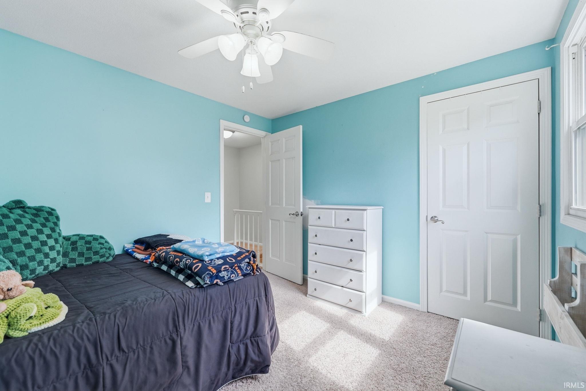 Room featuring light blue walls and neutral carpet flooring