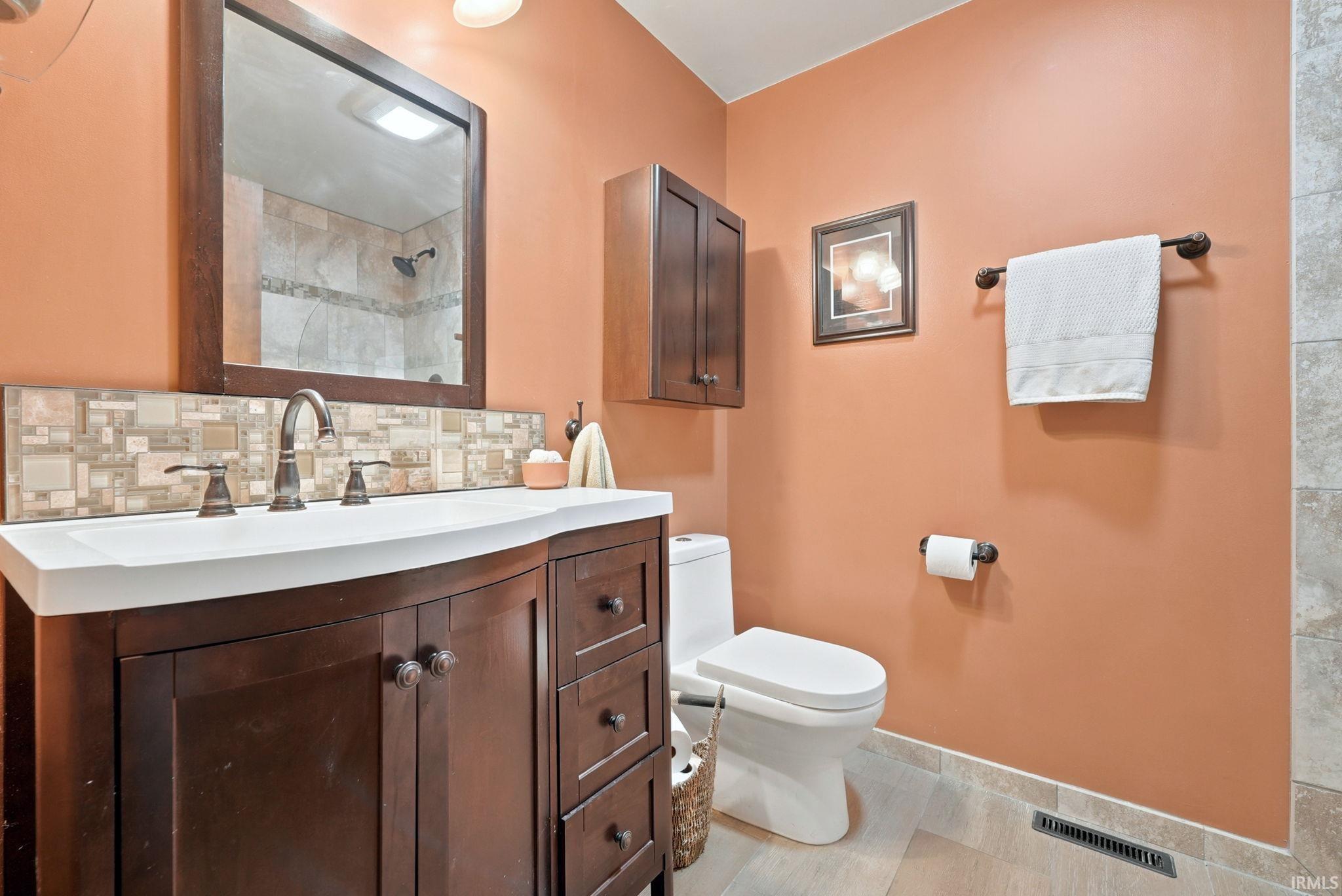 Bathroom featuring a dark wood-finish vanity with an integrated white sink and an oil-rubbed bronze faucet