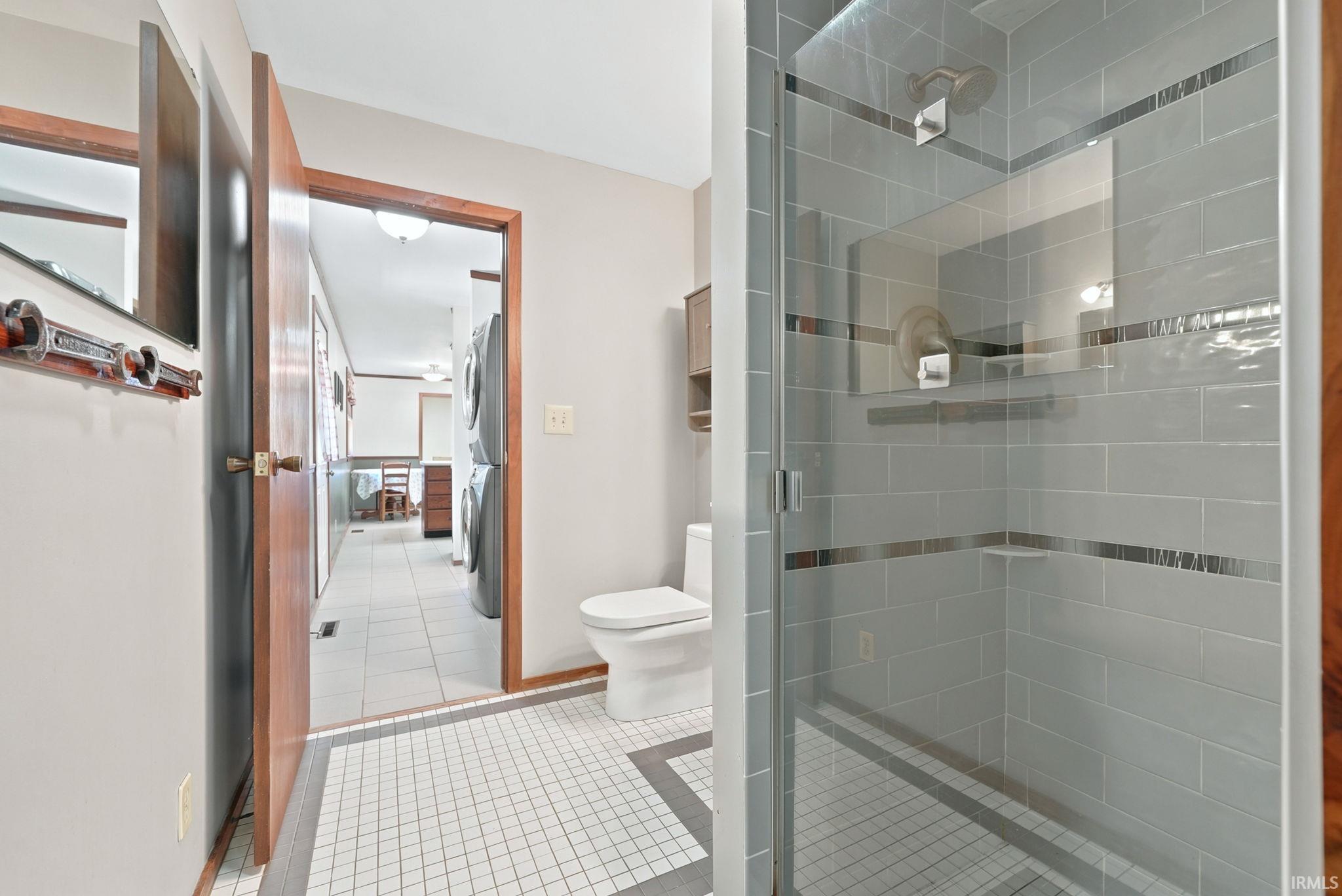 Bathroom featuring a glass-enclosed shower with subway tile surround and decorative accent bands