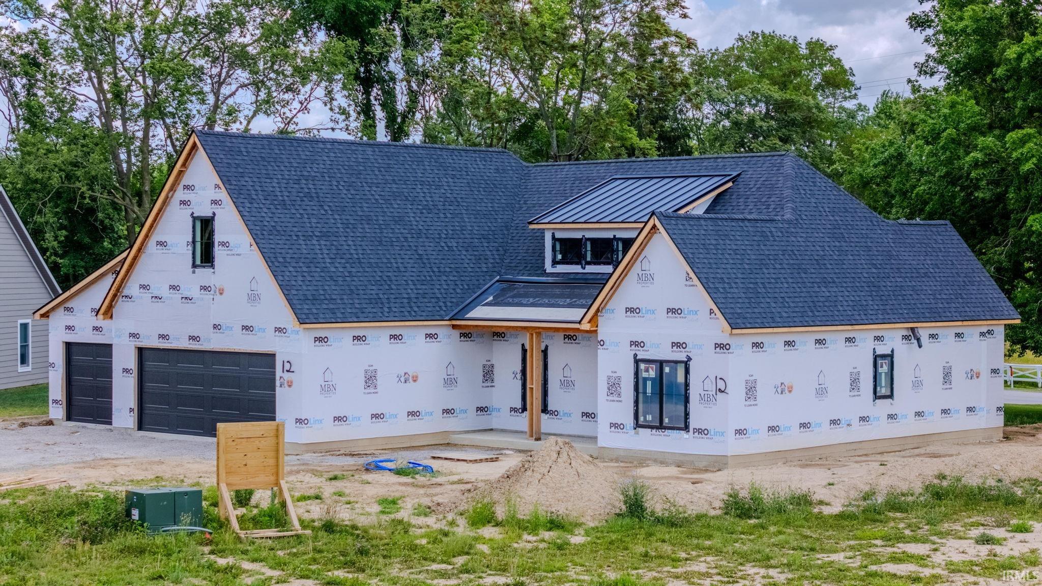 New construction residential structure featuring a dark shingle roof, contrasting black metal roof accent, and multiple gables