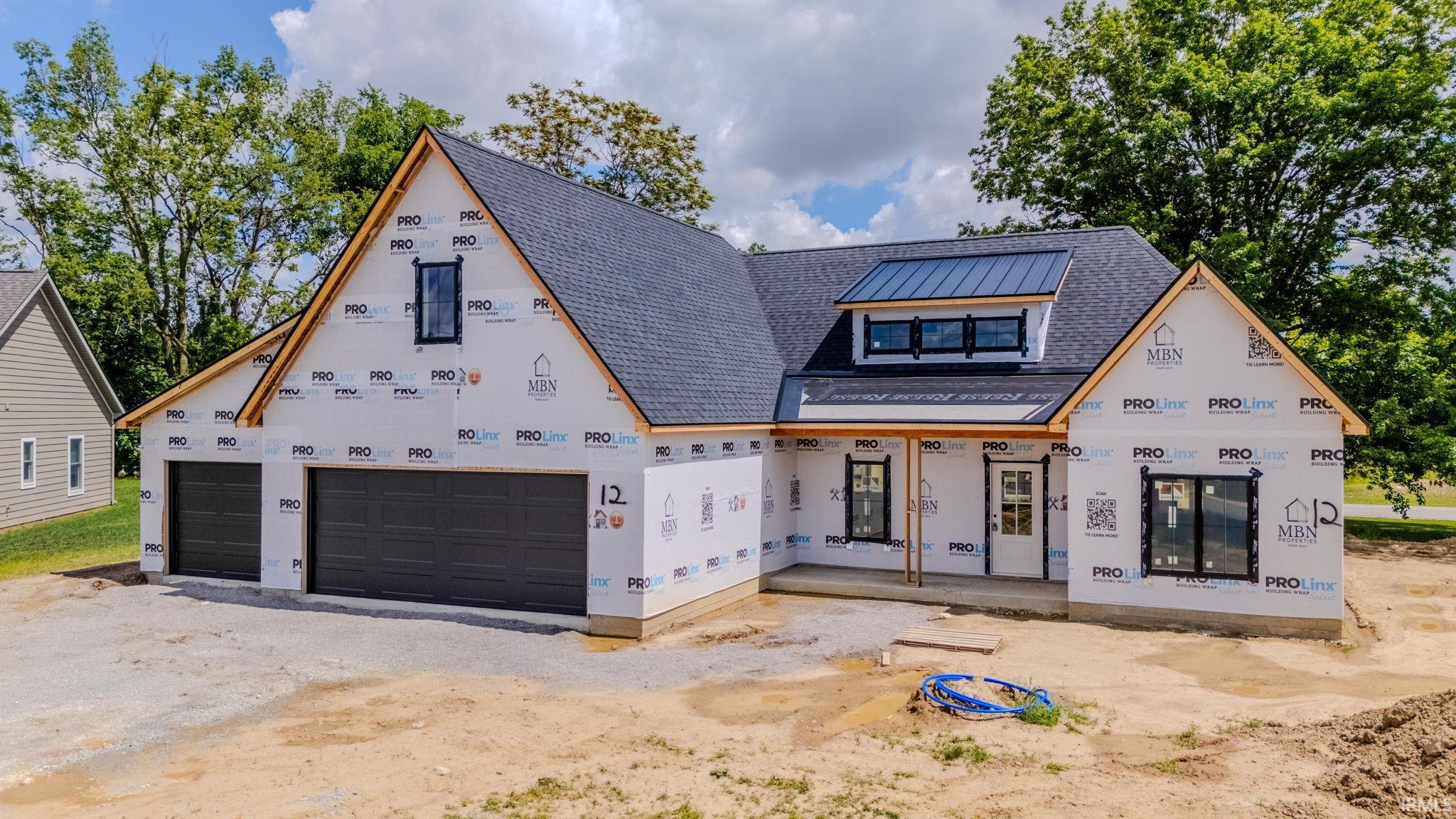 New construction featuring a dark shingle roof, black-framed windows, and a two-car garage with dark paneled doors