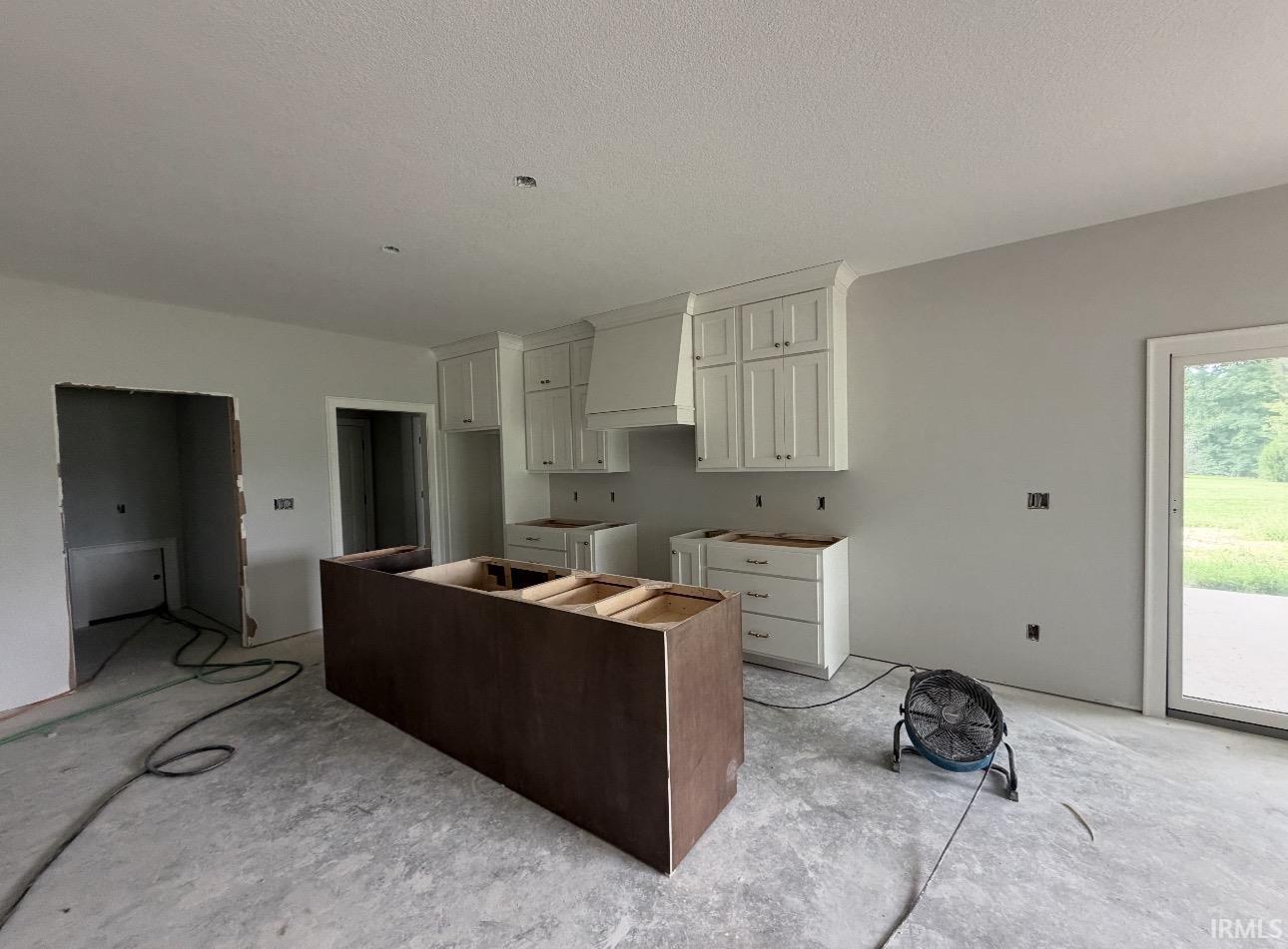 Kitchen featuring white upper cabinetry, white lower cabinetry, and a central island base
