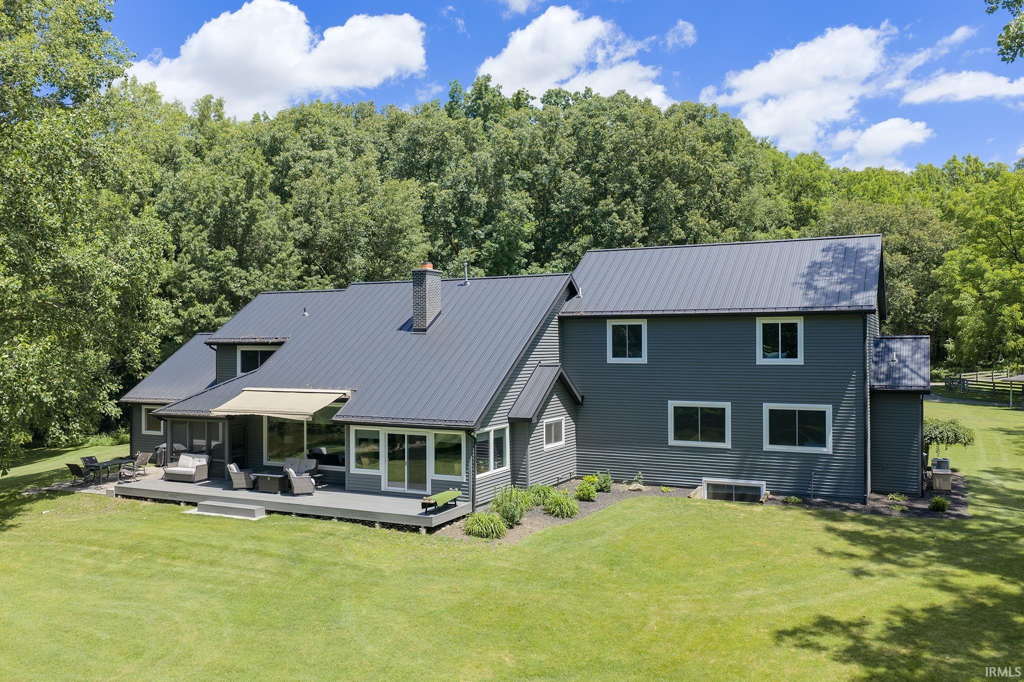 Contemporary residence featuring dark gray siding and a dark gray metal roof