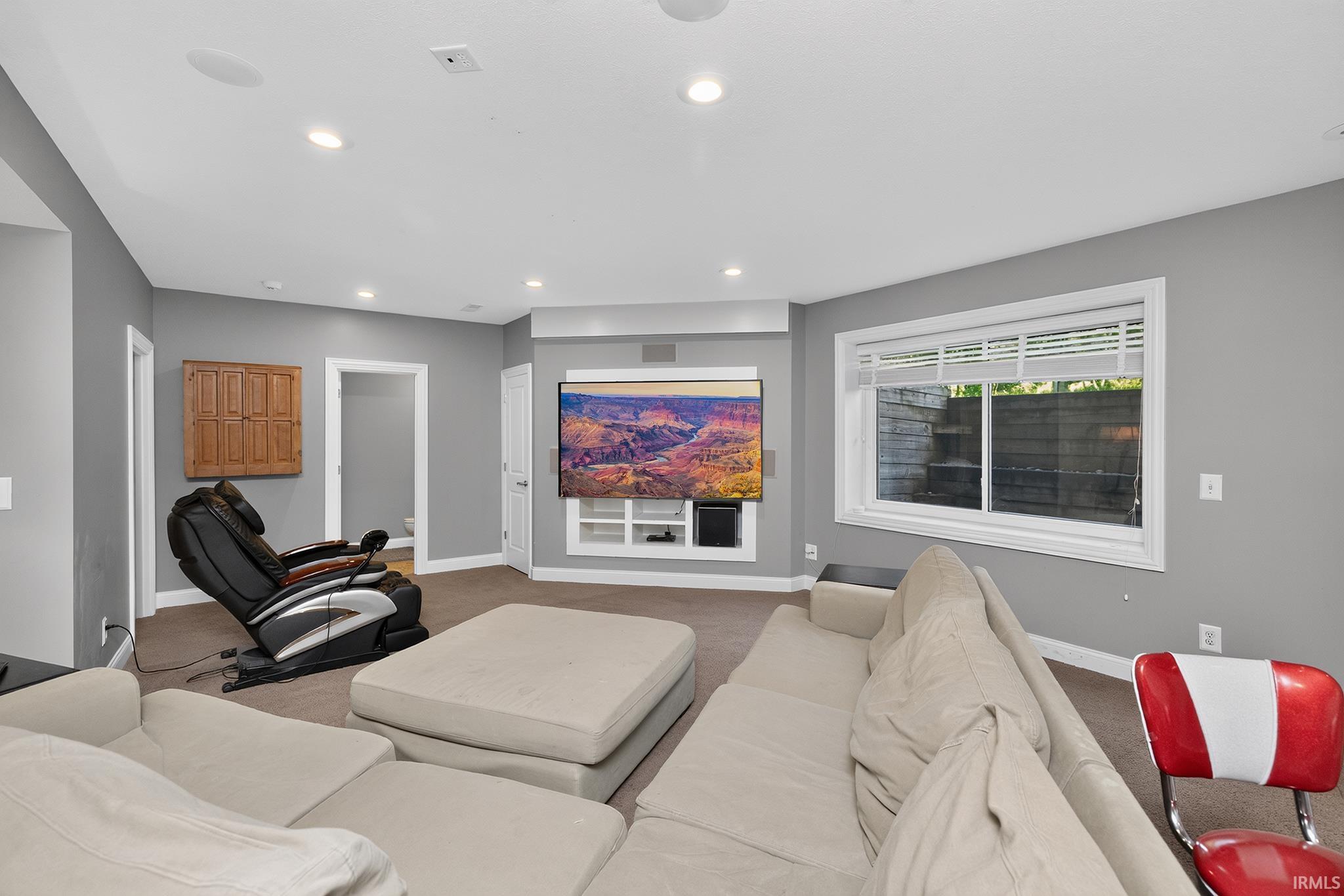 Entertainment space featuring recessed lighting, a built-in media console, a window with white blinds, and gray painted walls