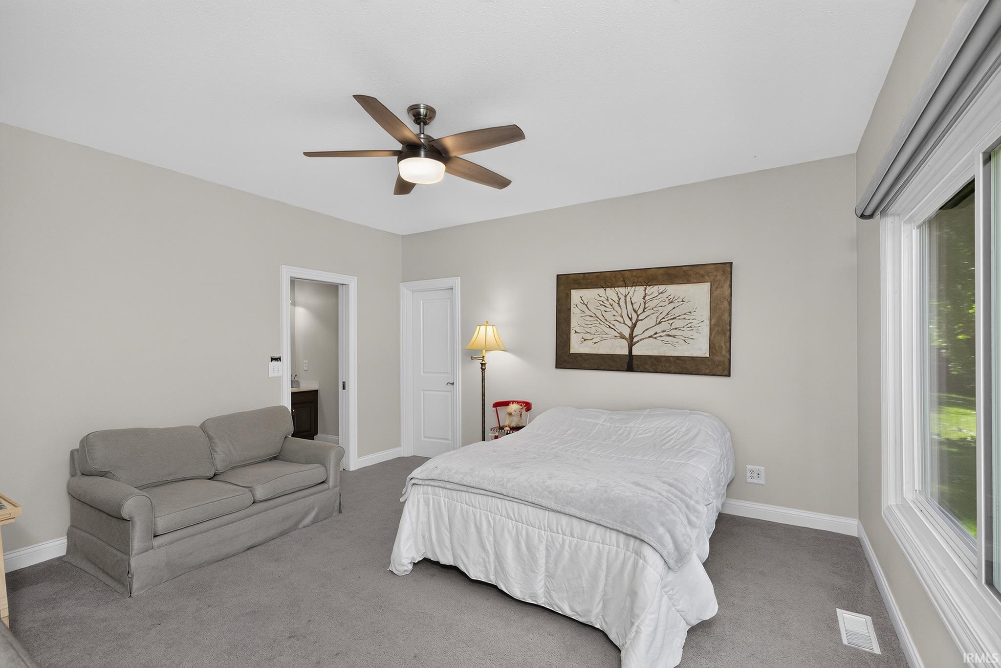 Carpeted room with a ceiling fan, a large window, and a light gray wall color