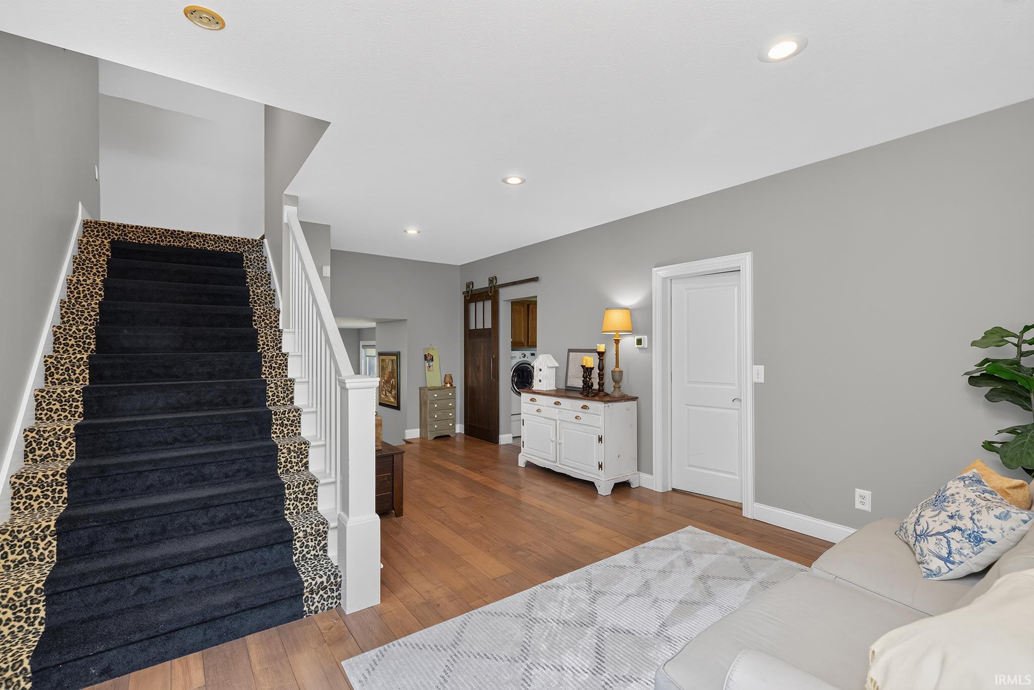 Staircase featuring a bold, patterned runner and white balusters