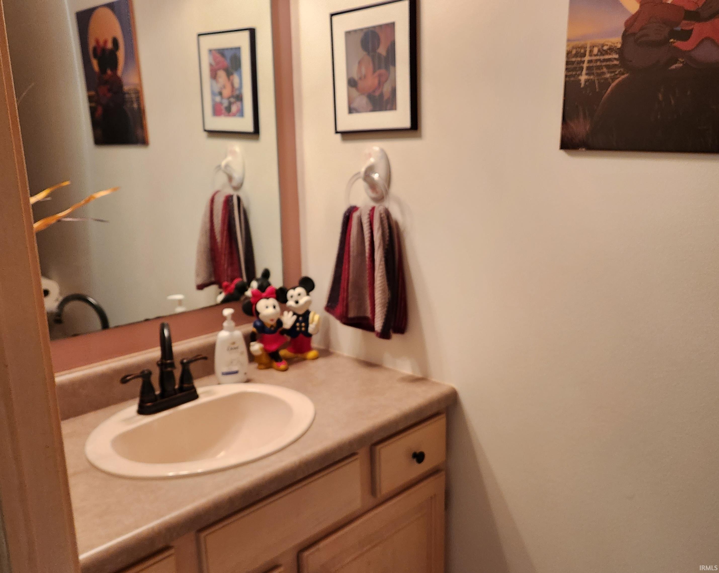 Built-in vanity with a light-toned countertop, integrated oval sink, and bronze-finish faucet