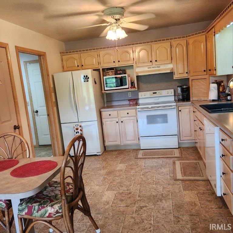 Kitchen featuring light wood cabinetry, laminate countertops, and a tile-look flooring