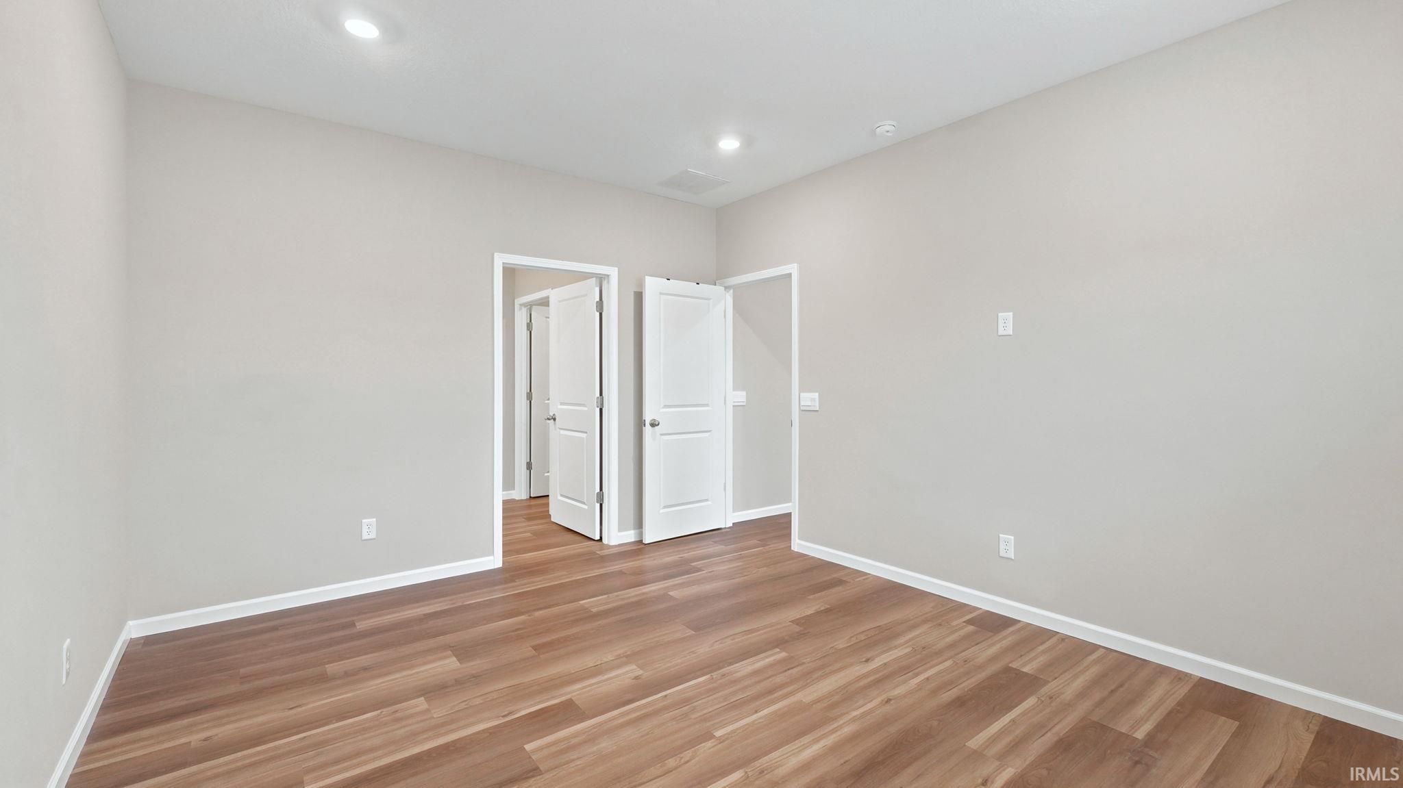 Room featuring wood-finish flooring, recessed lighting, neutral wall tones, and white trim