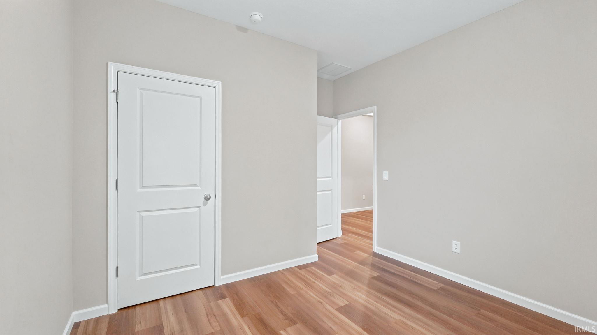 Neutral-toned room featuring wood-finish flooring