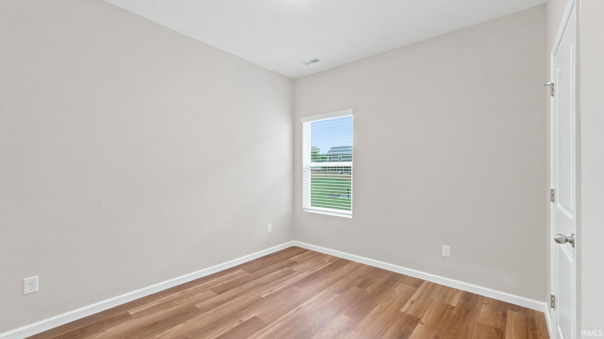 Bright interior room featuring wood-finish flooring and neutral wall tones