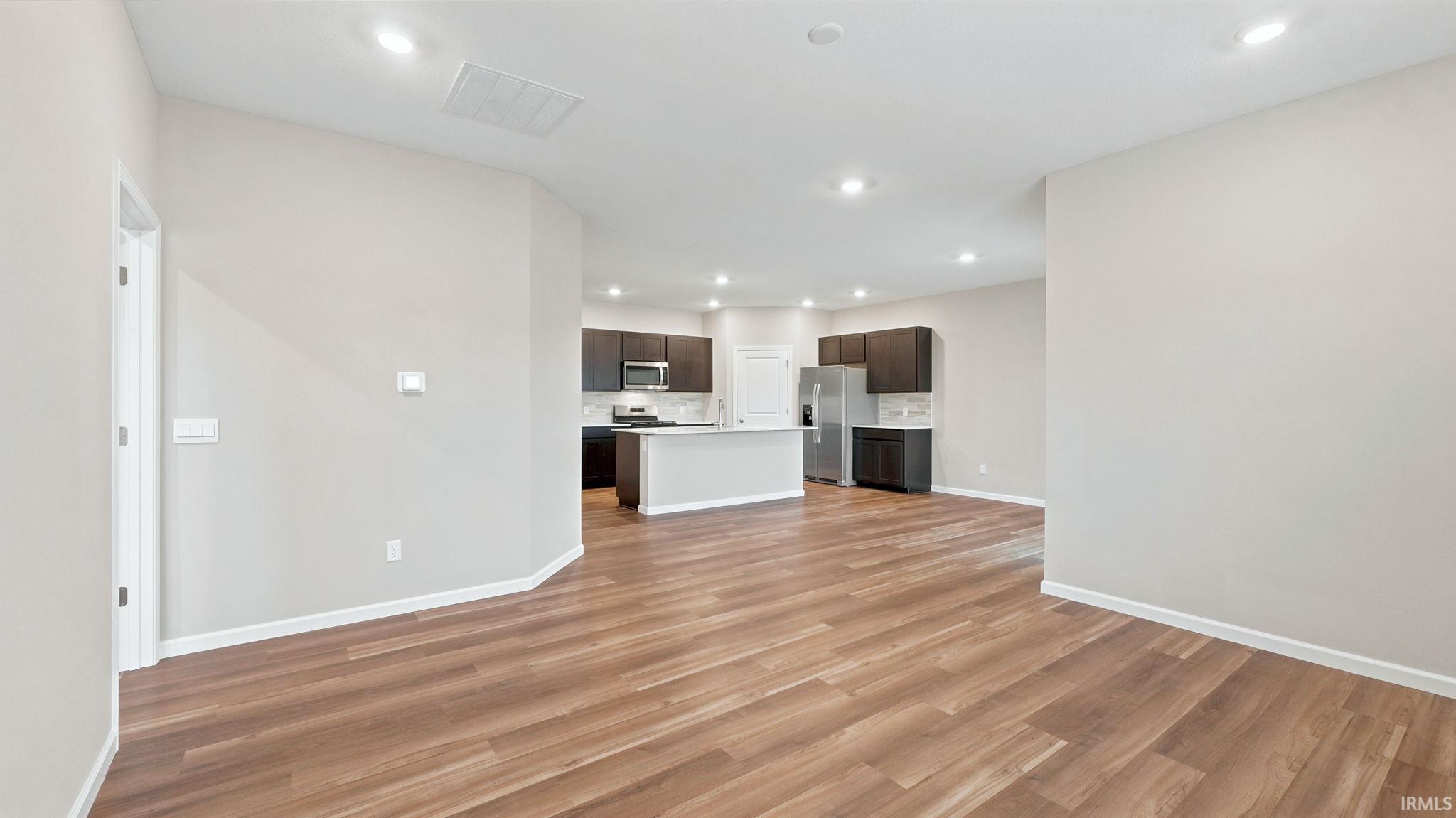 Open concept living area featuring wood-finish flooring, recessed lighting, and light neutral wall tones