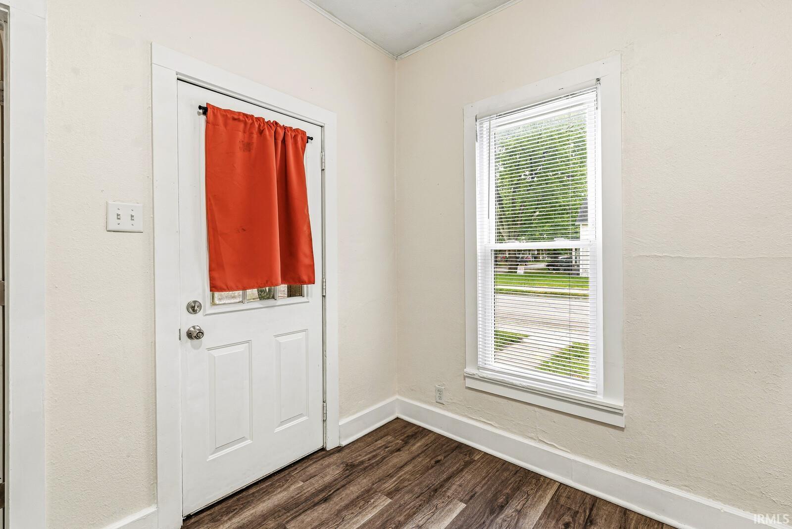 Entryway featuring a white paneled door with an upper glass insert, wood-finish flooring, white trim, and light-toned walls