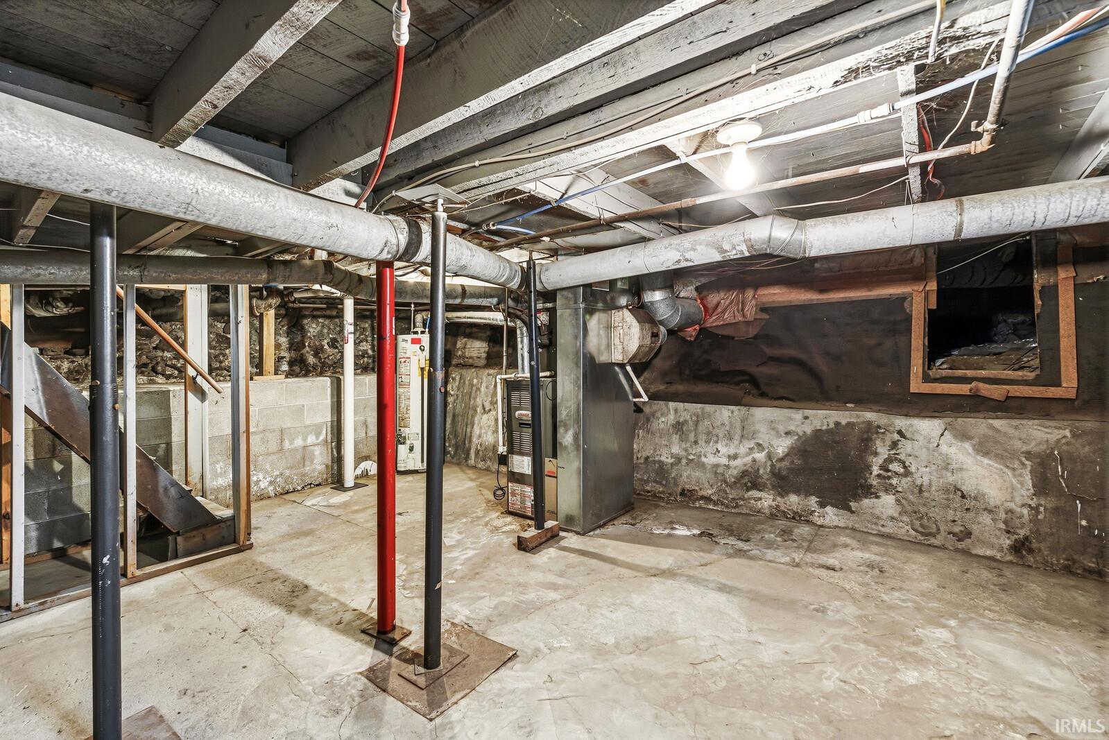 Unfinished basement featuring exposed joists and concrete flooring