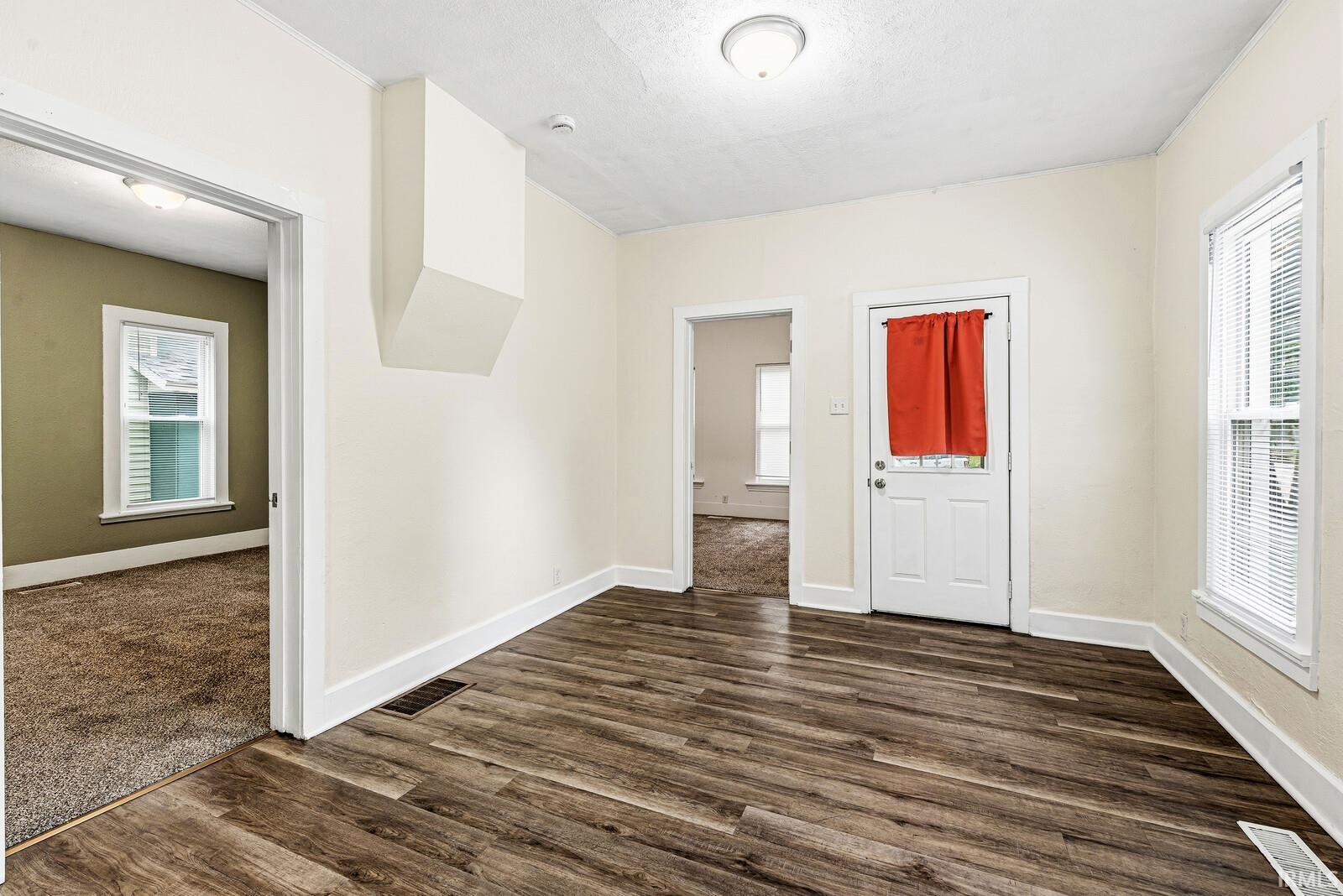 Wood-finish flooring throughout the main room, featuring white baseboards and trim