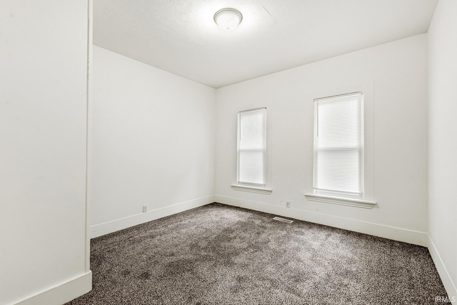Room featuring neutral-toned textured carpeting and light-colored walls