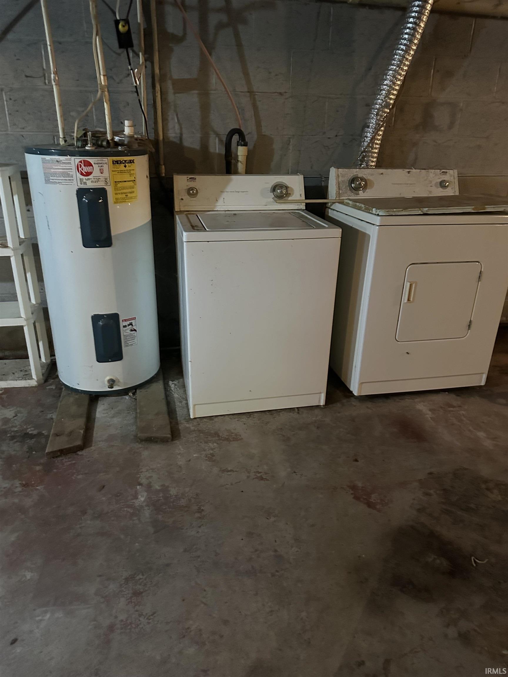 Dedicated laundry area featuring a top-load washer and dryer set, adjacent to a water heater