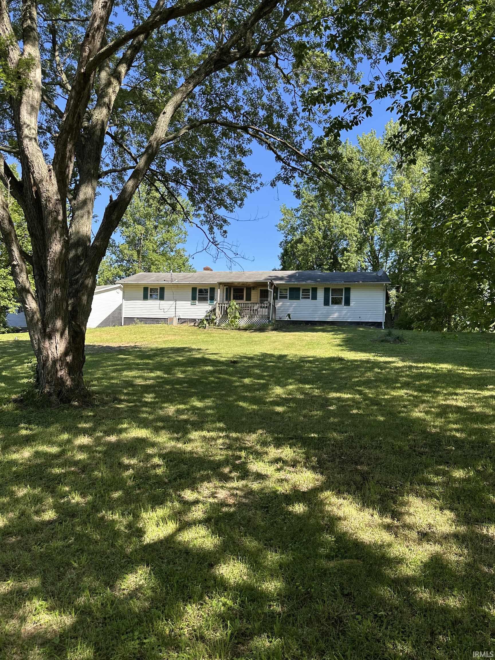 Ranch-style residence featuring a white exterior with green shutters and an inviting front porch