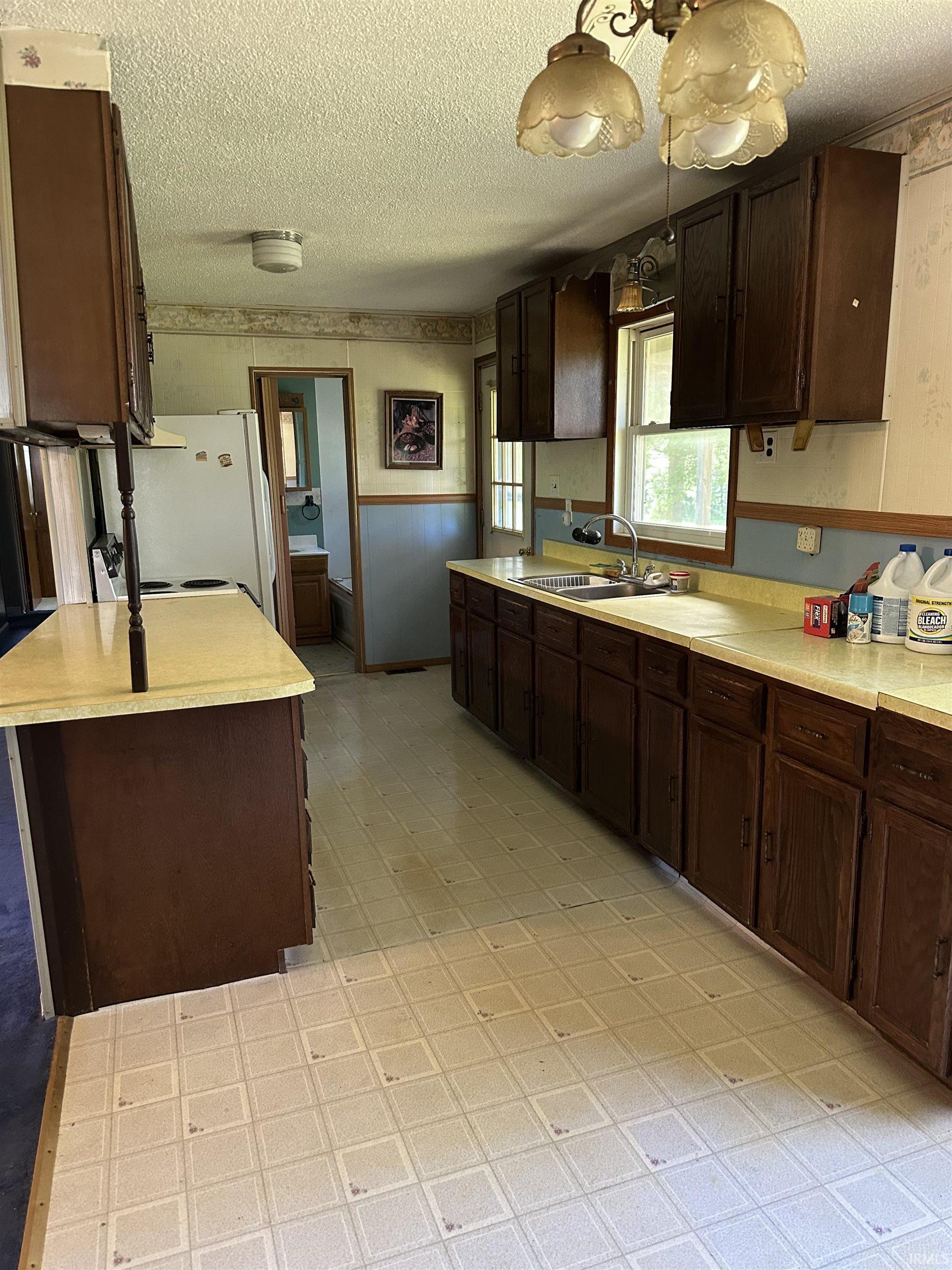 Kitchen featuring extensive cabinetry with wood-finish doors and light-toned laminate countertops
