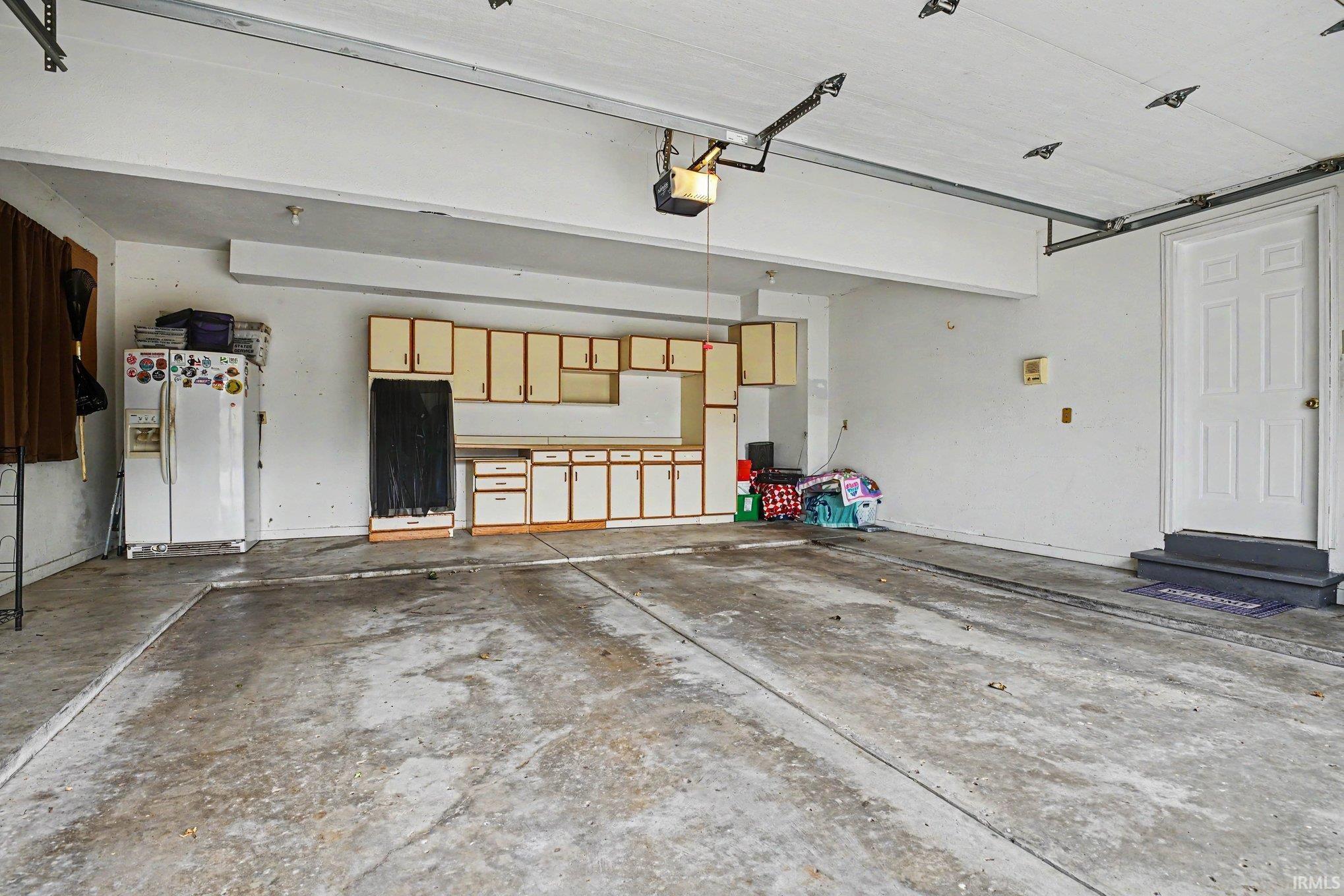 Spacious garage featuring concrete flooring and a paneled white door