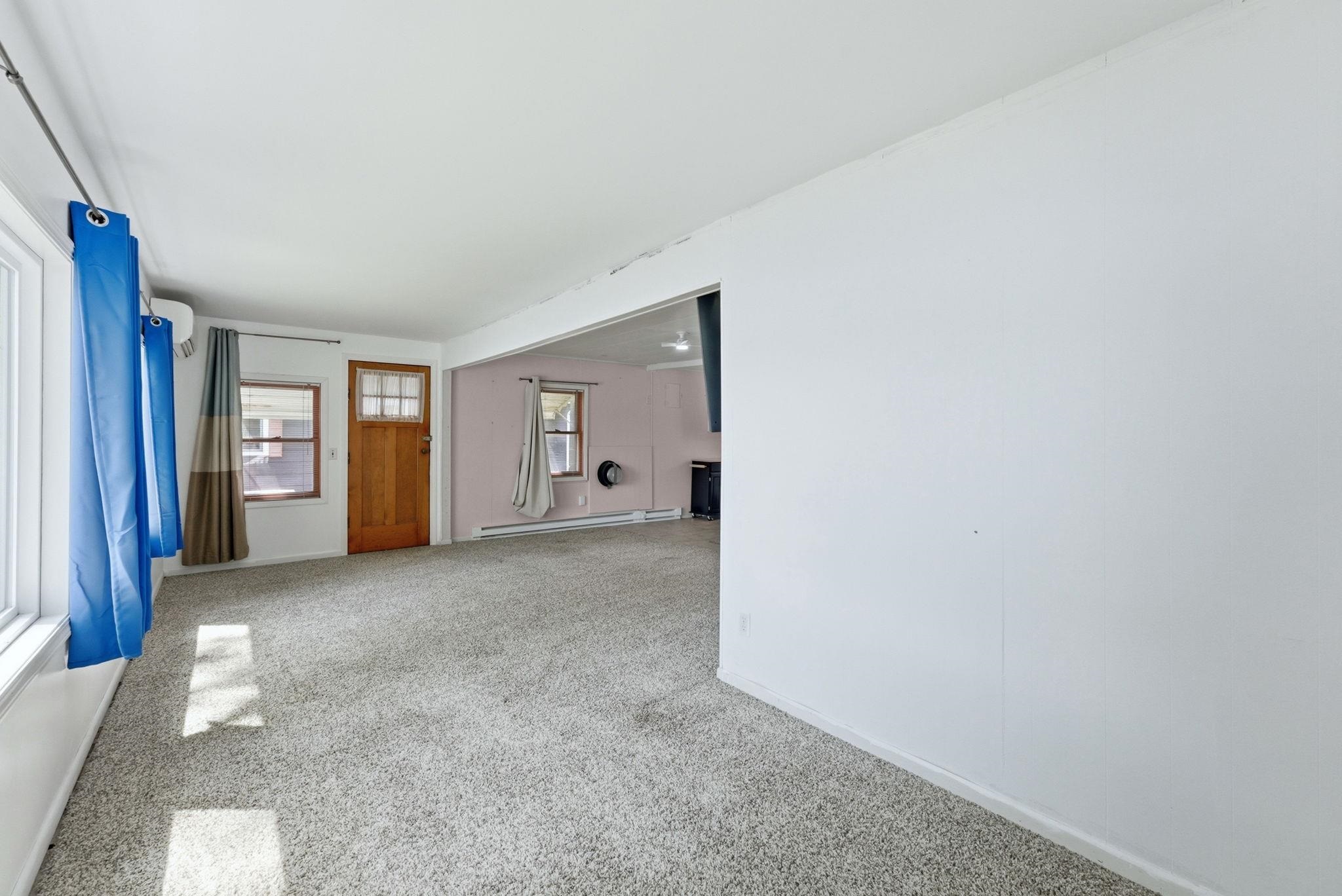 Spacious room featuring light-toned carpeting and white walls
