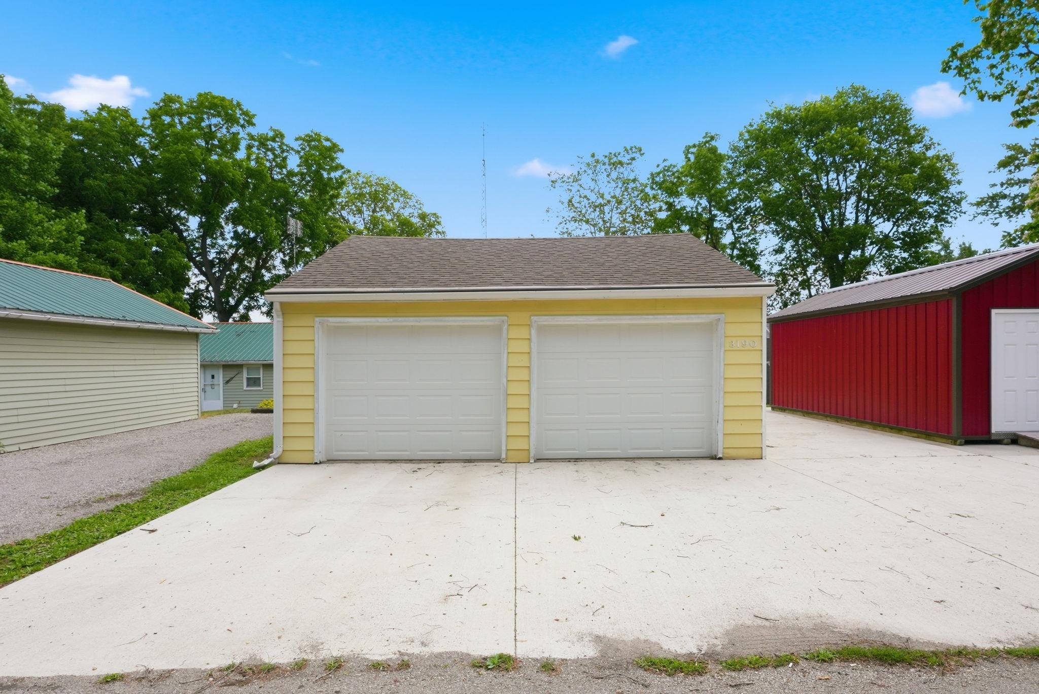 Two-car garage with yellow siding and a concrete driveway