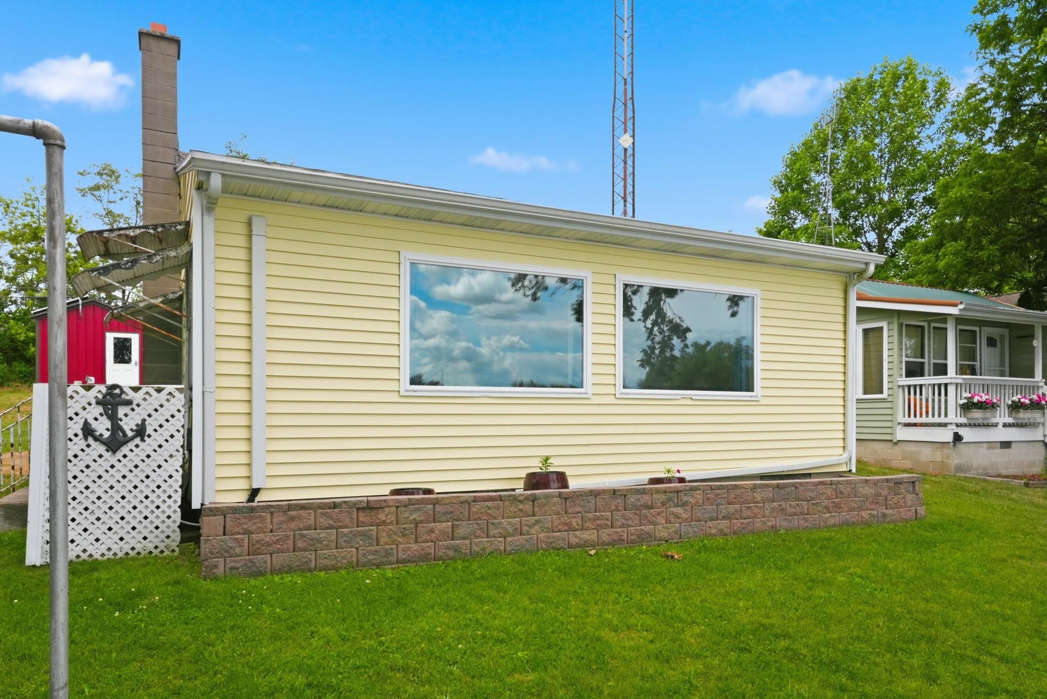Property exterior featuring yellow siding and a decorative block retaining wall