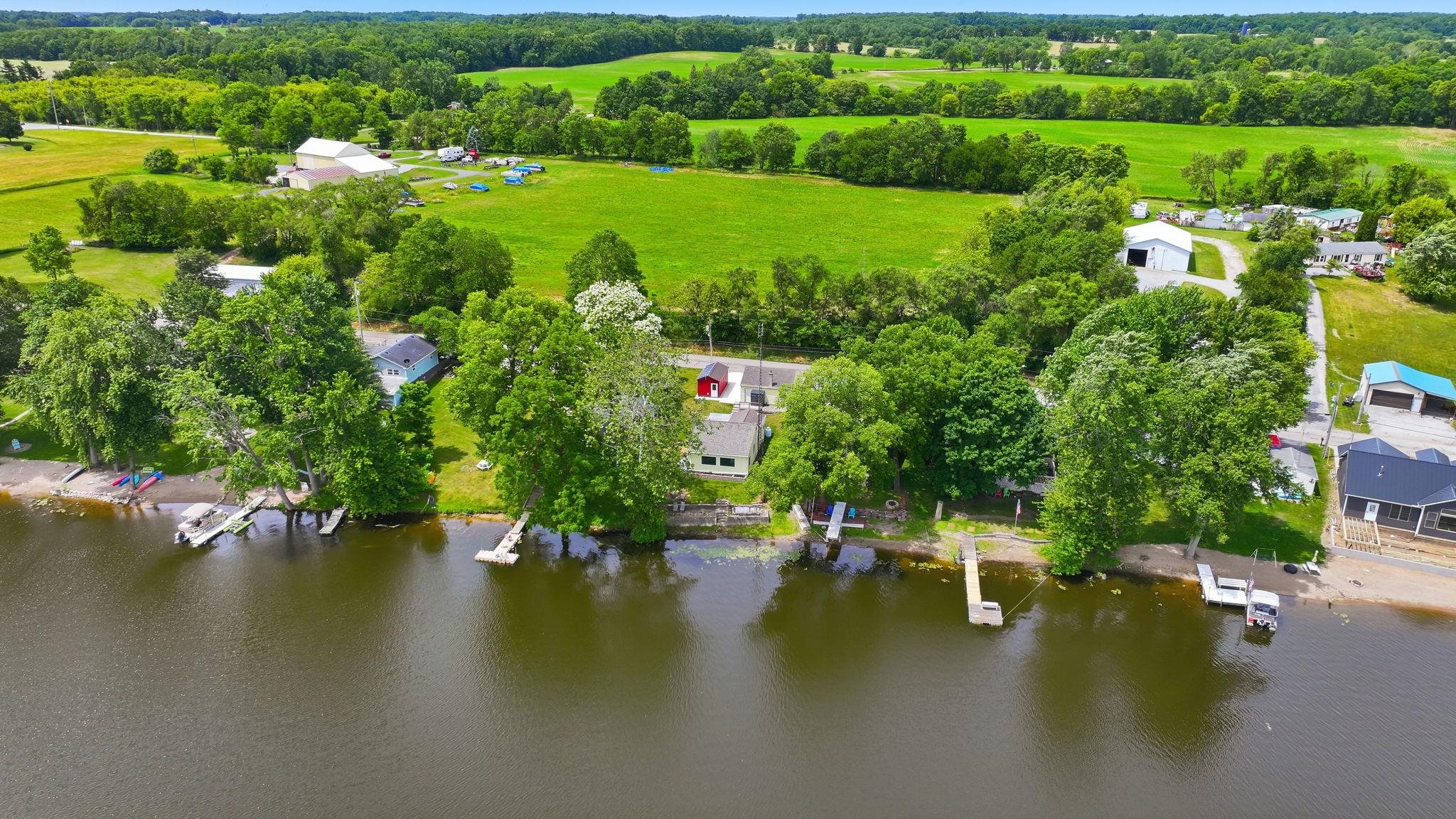 Waterfront property featuring multiple private docks and mature trees