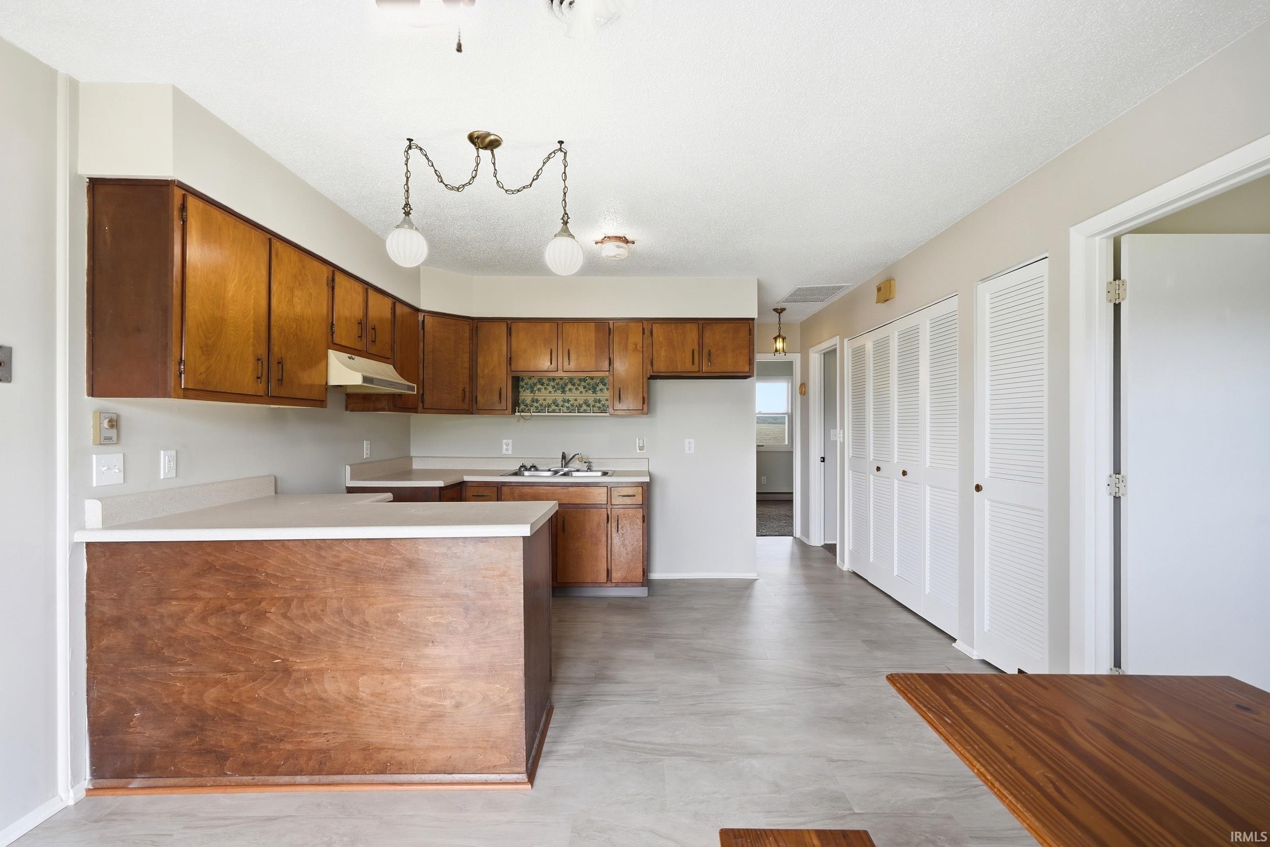 Kitchen featuring wood cabinetry, light-toned countertops, and a decorative tile backsplash