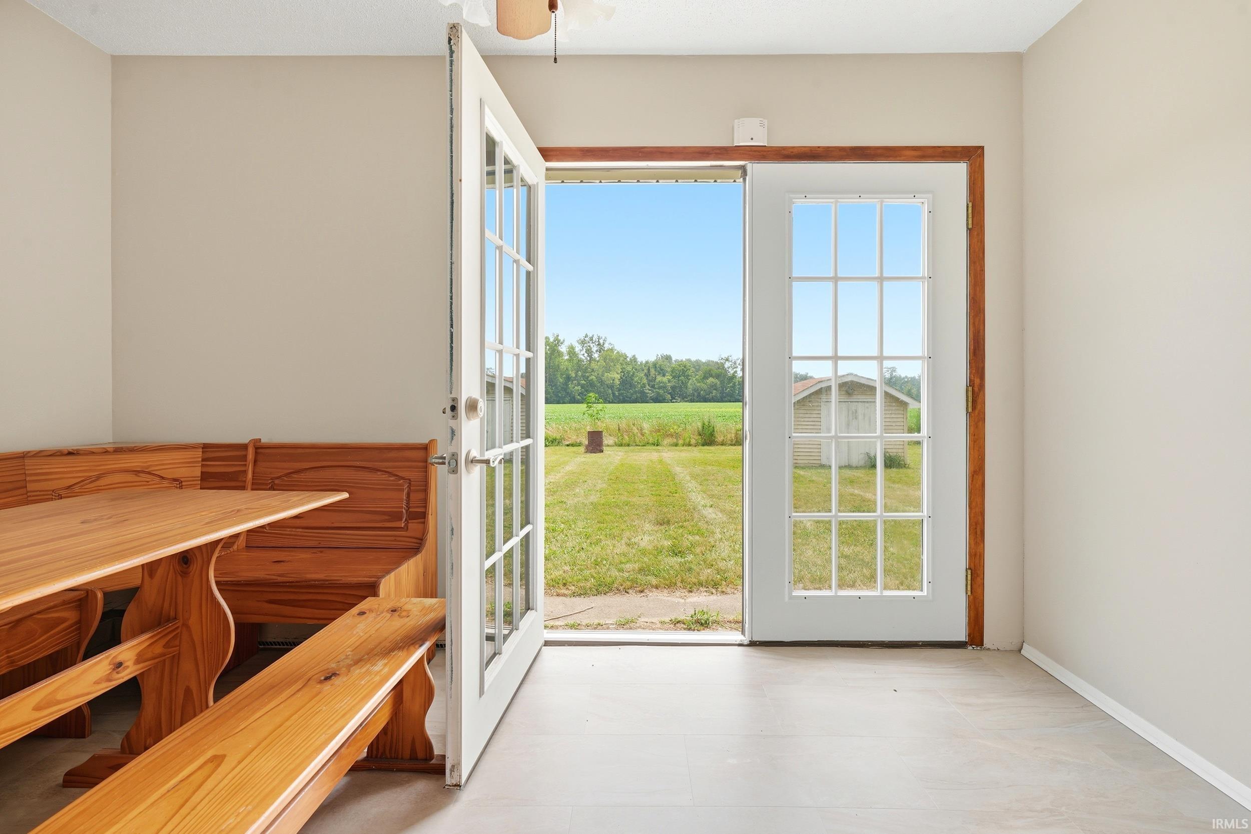 Dual French doors with gridded lites open to a grassy exterior