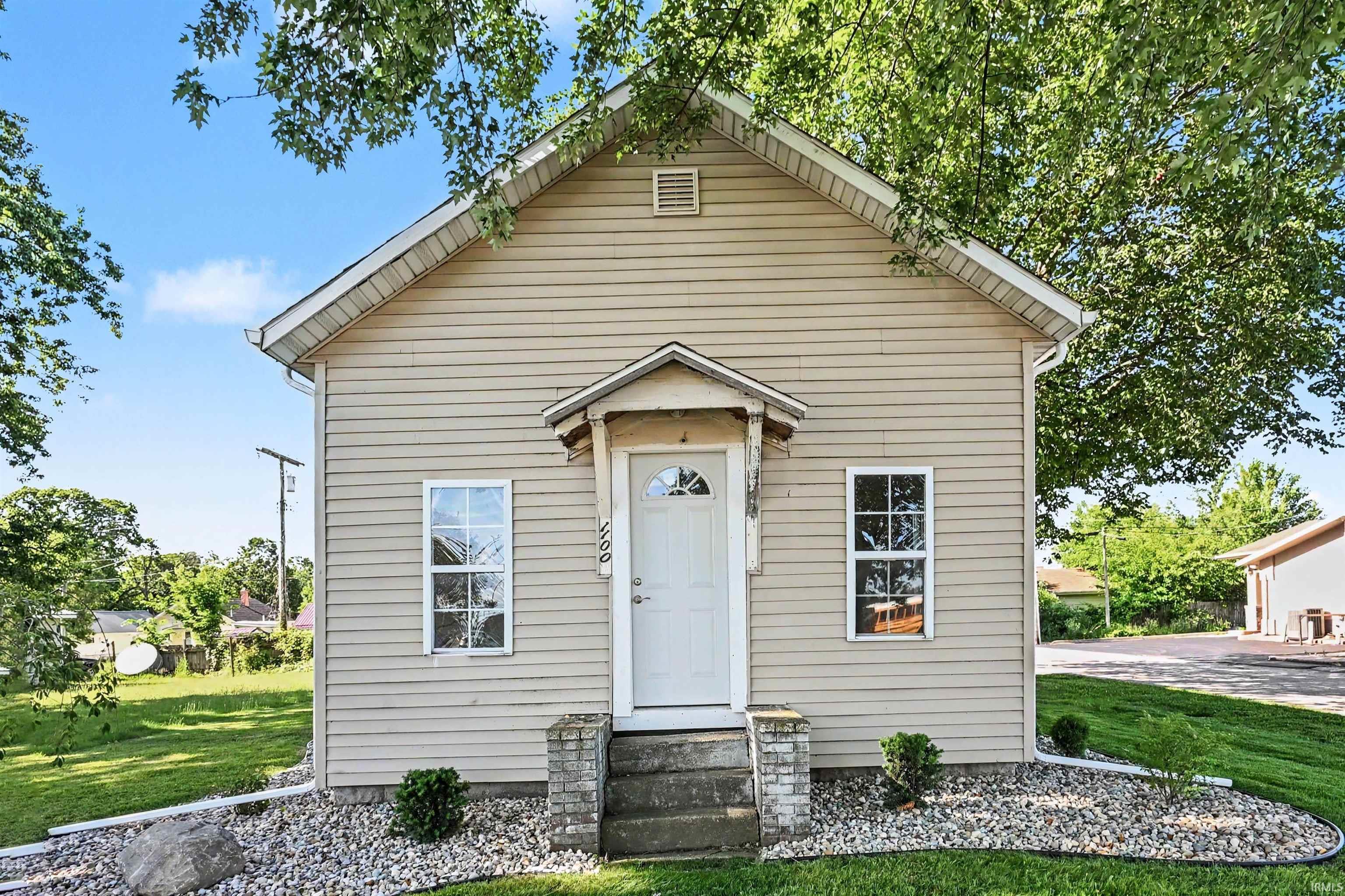 Gabled residential facade featuring horizontal siding and a portico entry
